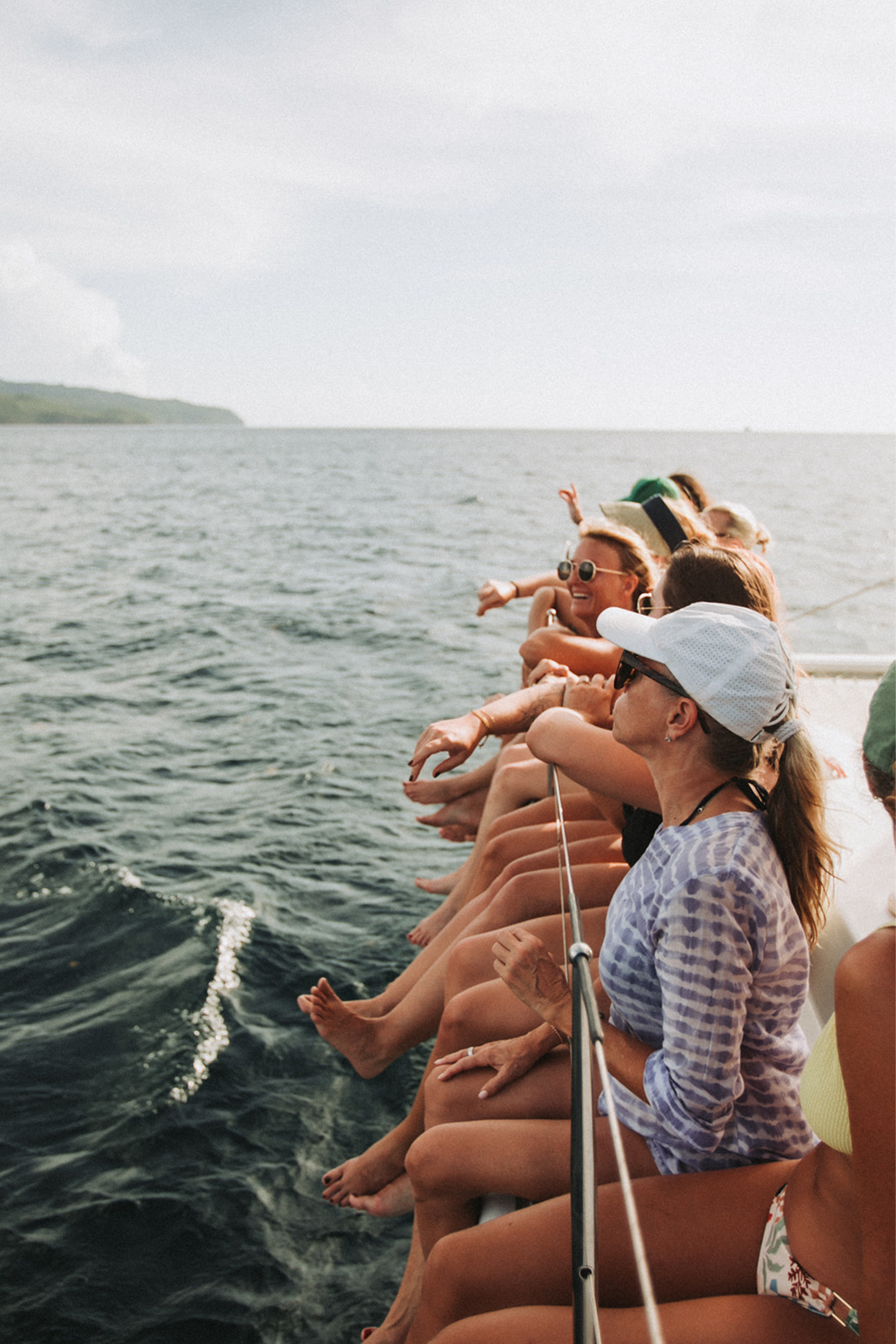 Group of women relaxing on a boat during a coastal wellness retreat experience on the water.