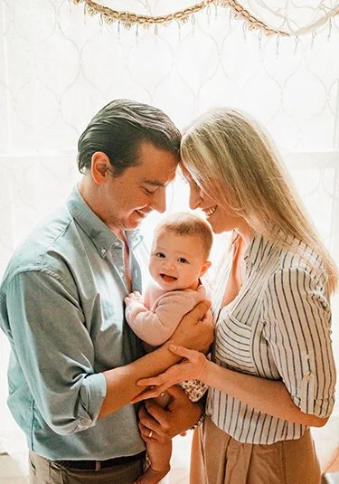 Family holding a baby together while exploring Hello Baby adoption consulting services.