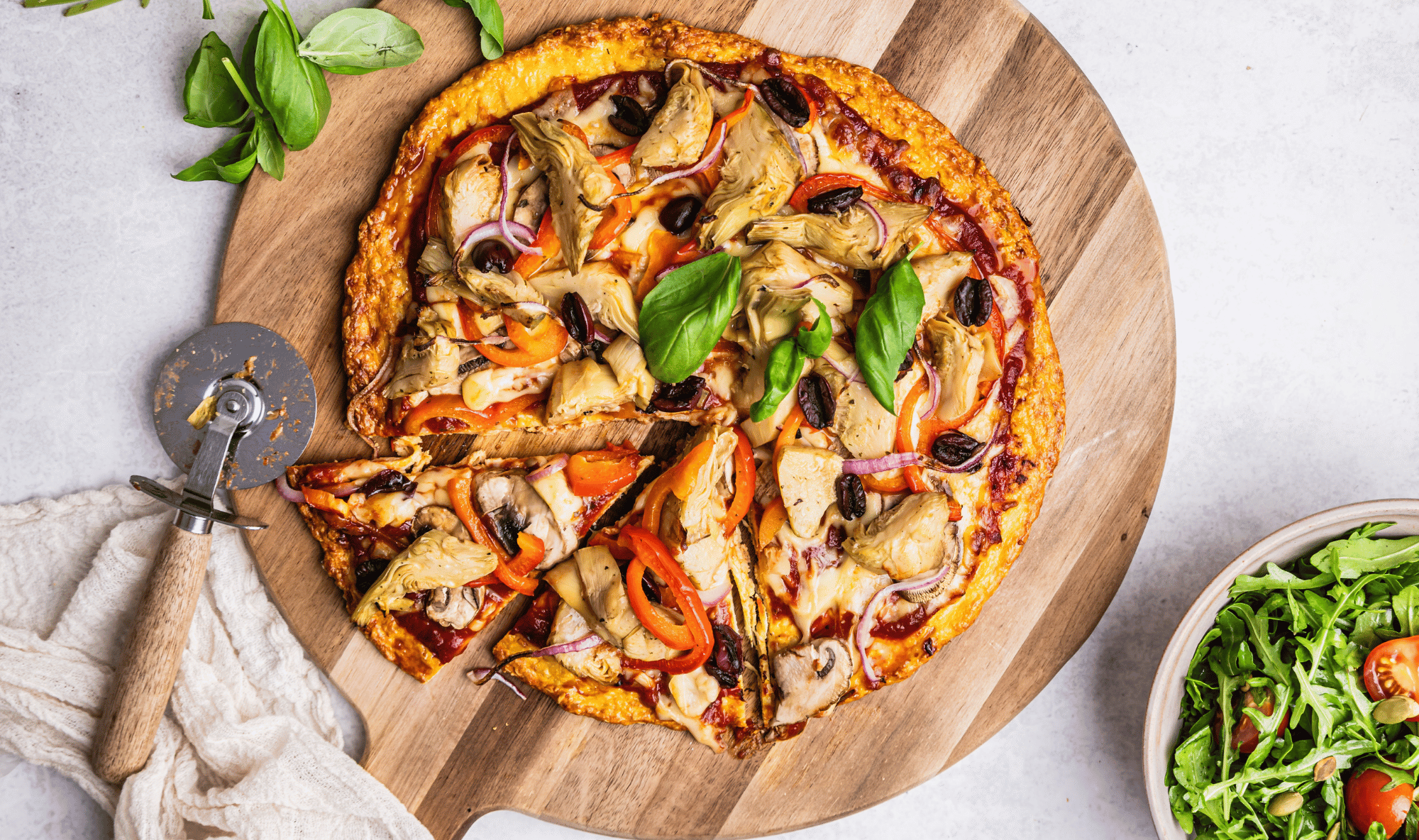 Chicken crust pizza with veggie toppings and rocket salad