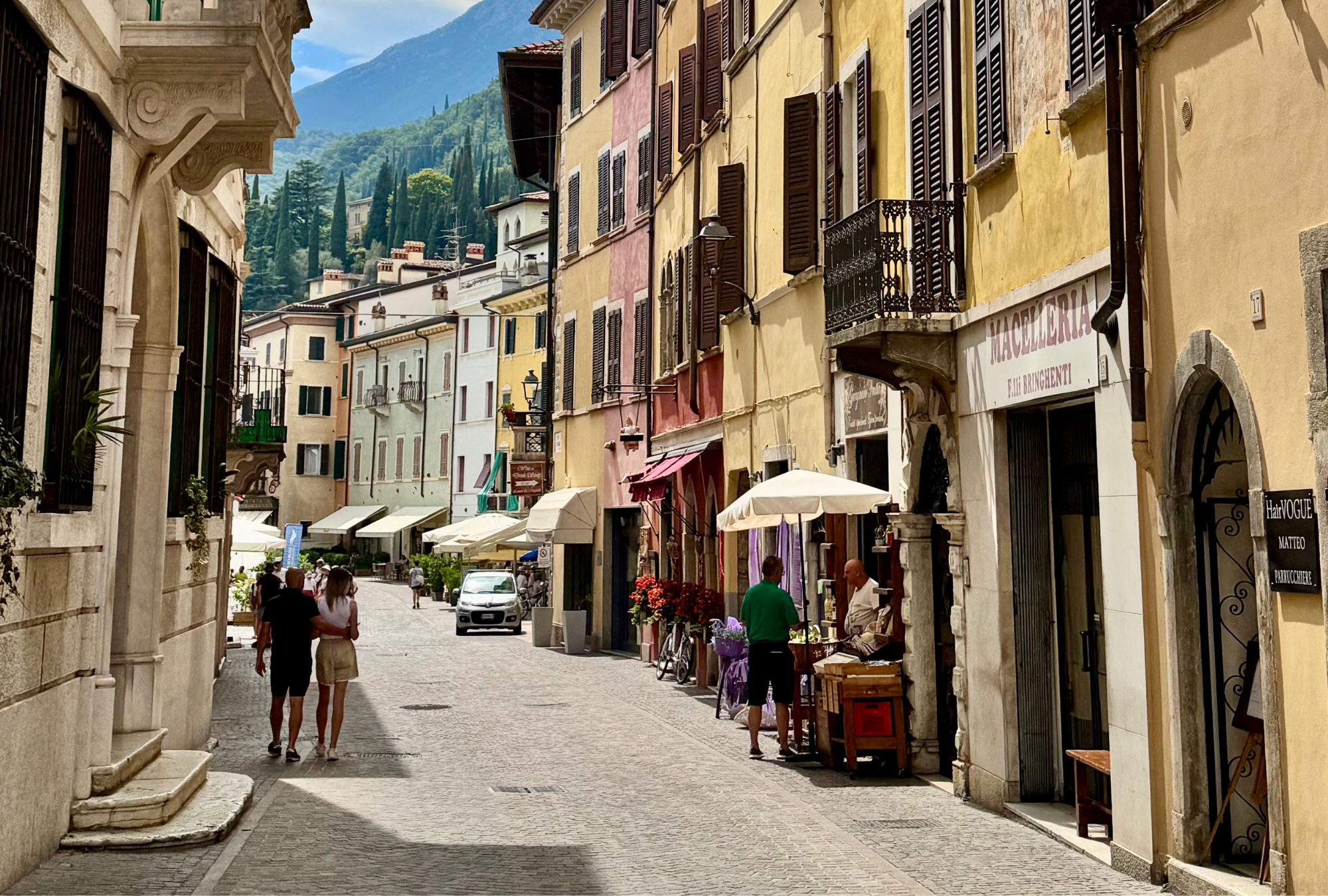 Locals walking through a cobblestone street in an Italian town