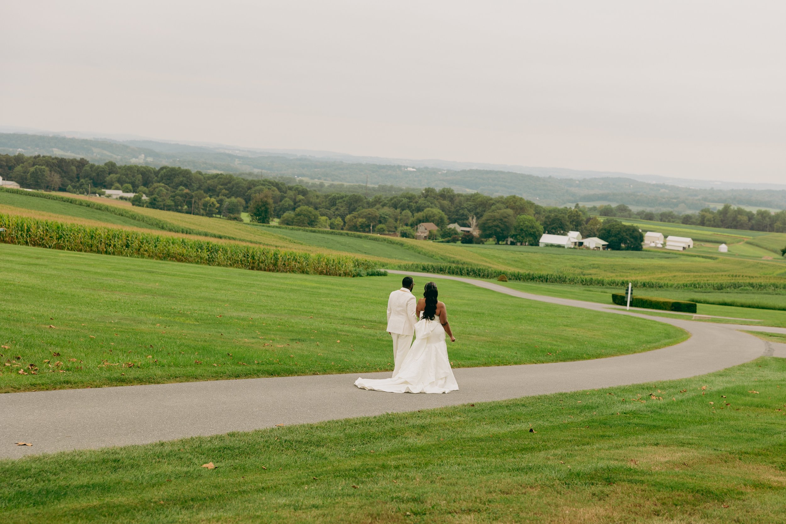 A bride and groom share a close, intimate moment, with their foreheads touching, smiling beneath a veil.