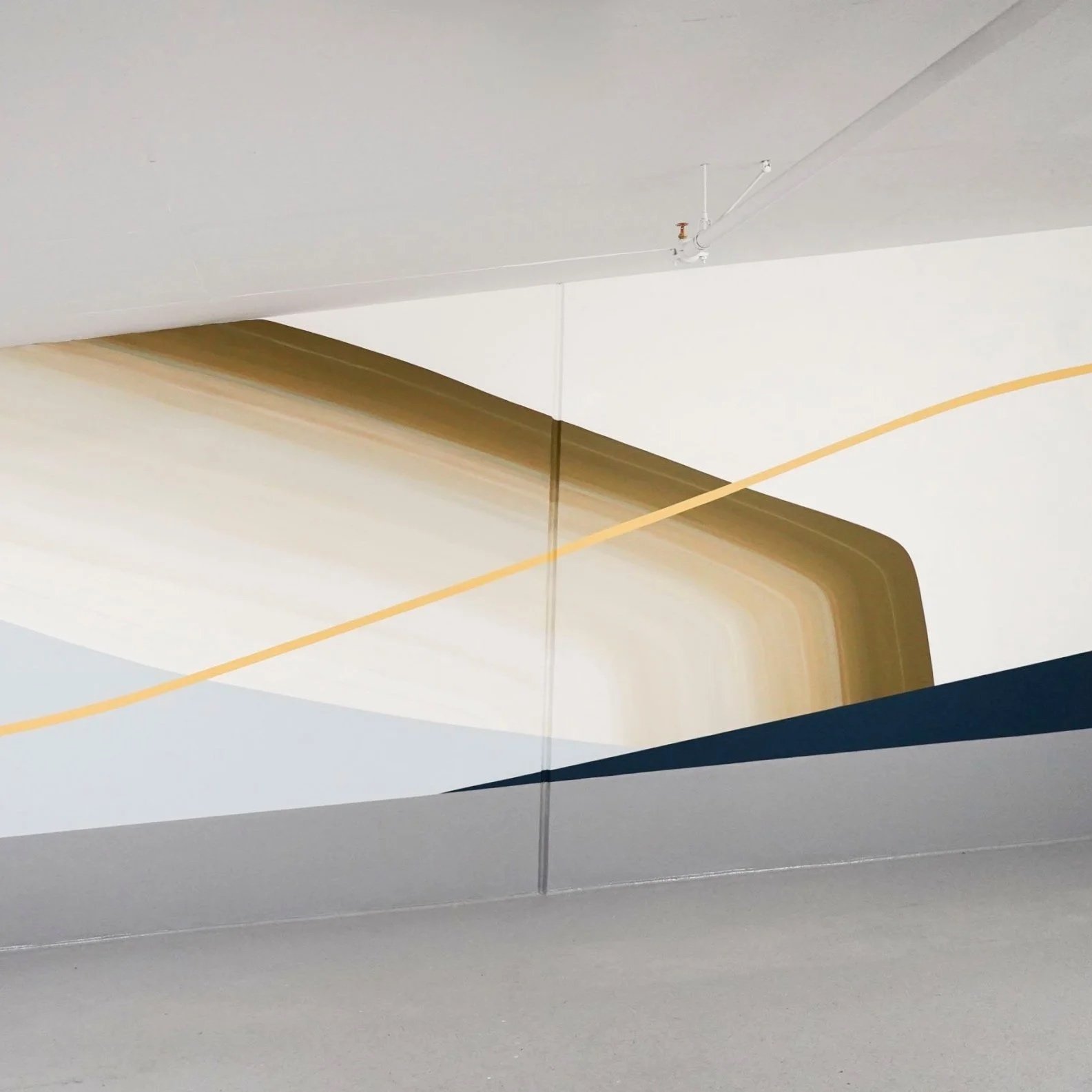 Amy Stewart abstract prints installation of an Abstract wall mural with geometric shapes and colors, including beige, blue, yellow, and white, on a modern interior wall.