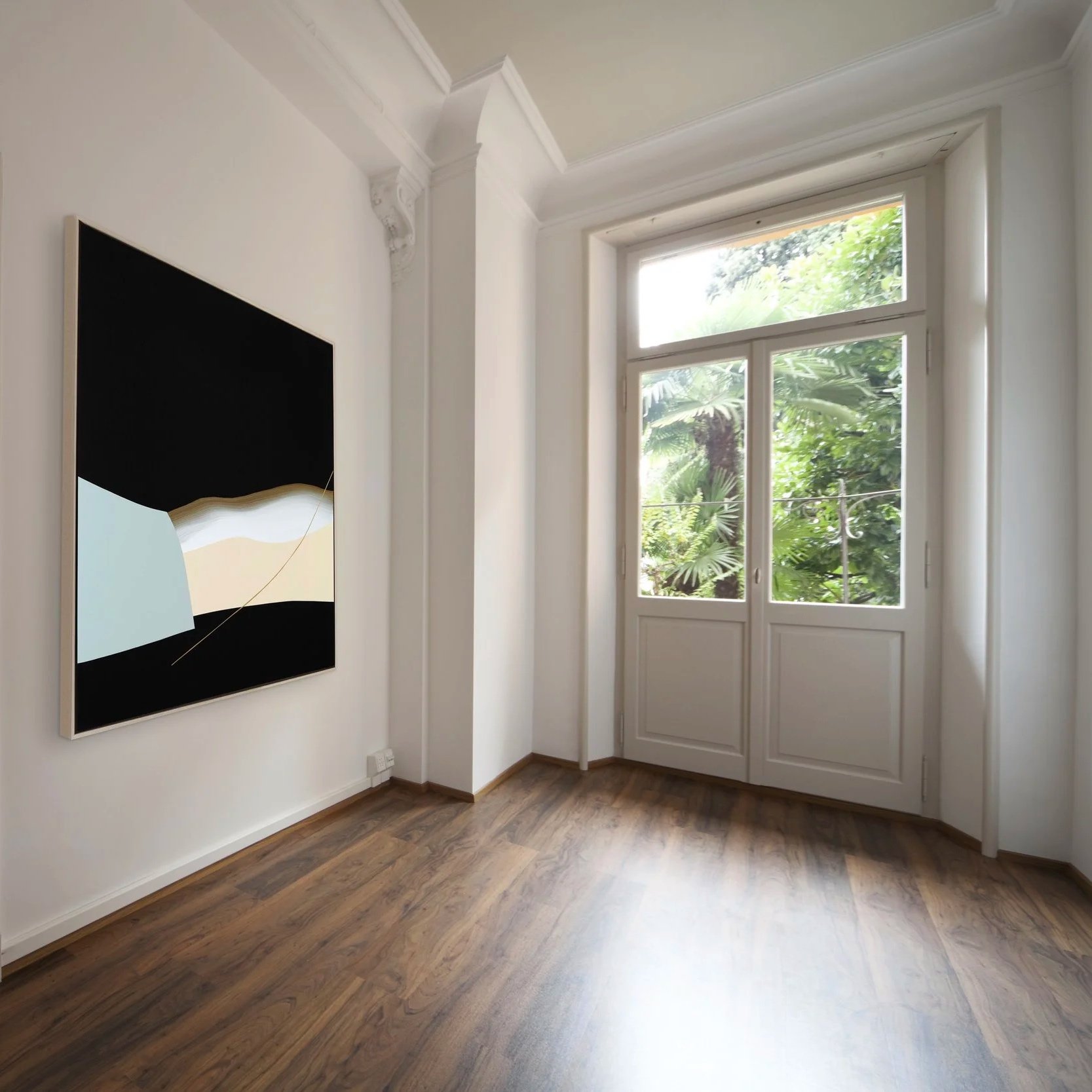 Amy Stewart abstract prints,  A room with white walls, a large window, and a piece of abstract black and white artwork on the wall. The room has wooden flooring and decorative molding near the ceiling.