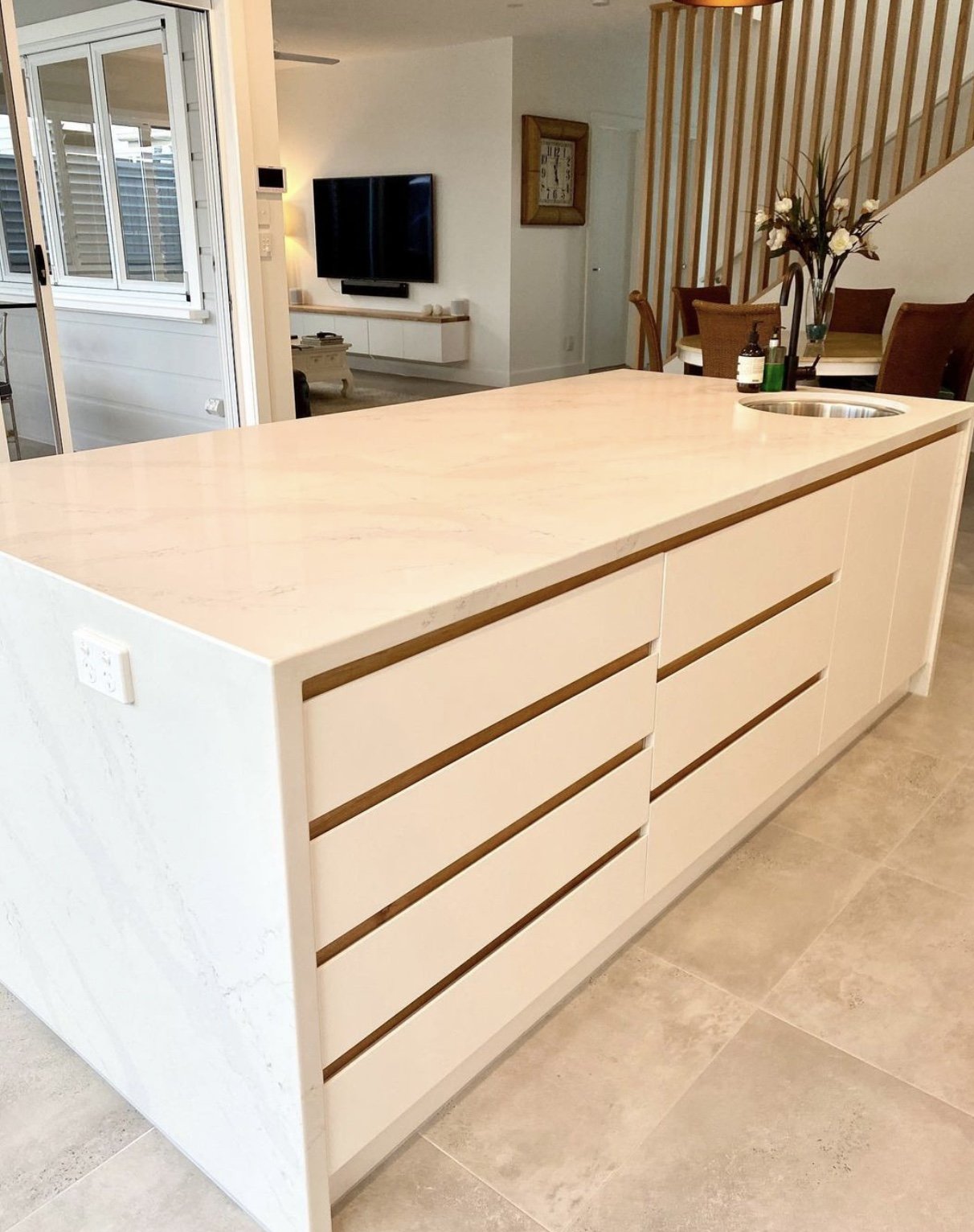 Renovated open-plan kitchen and living area with white stone island bench