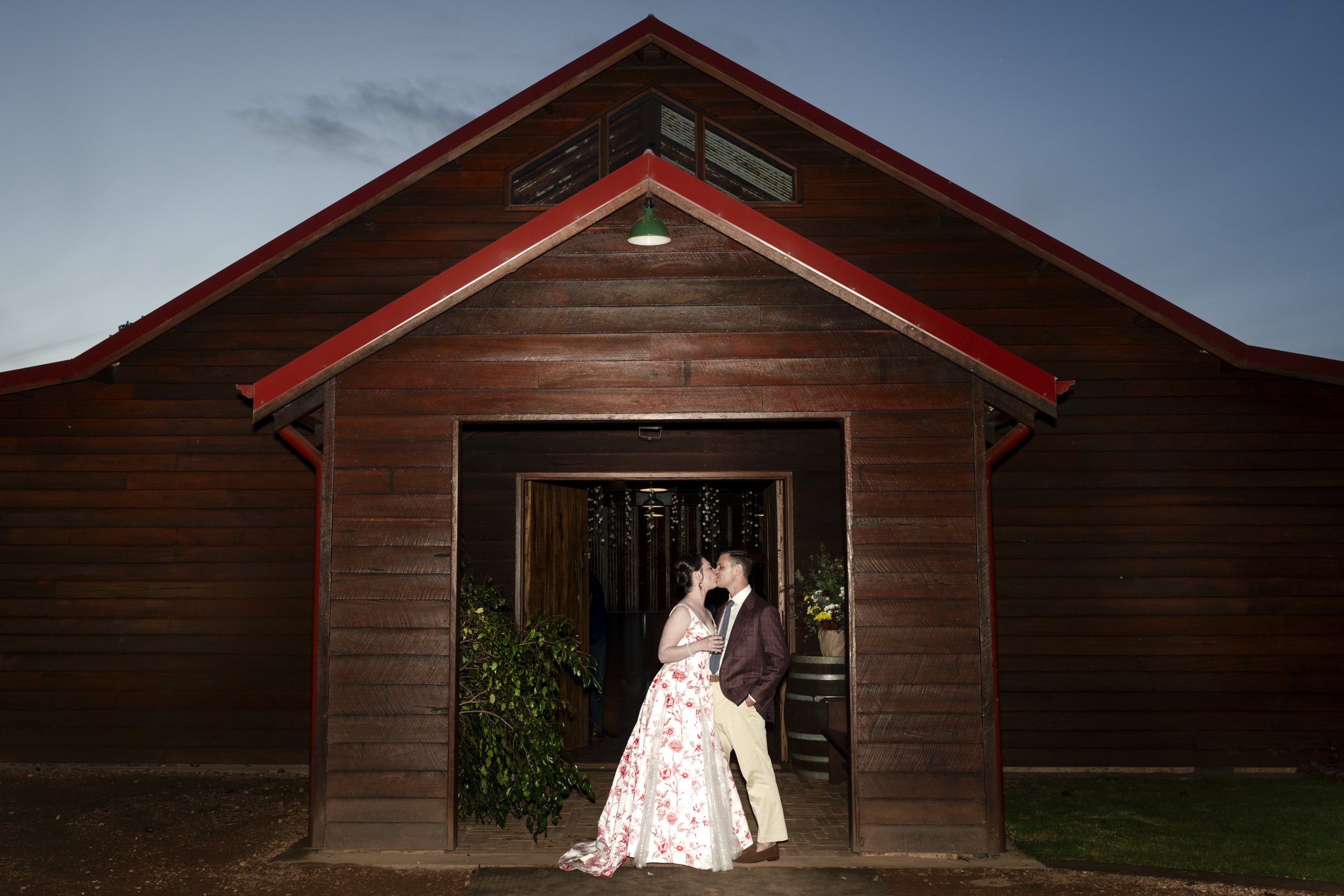 Wedding couple standing in front of a portico of a wooden bespoke made barn
