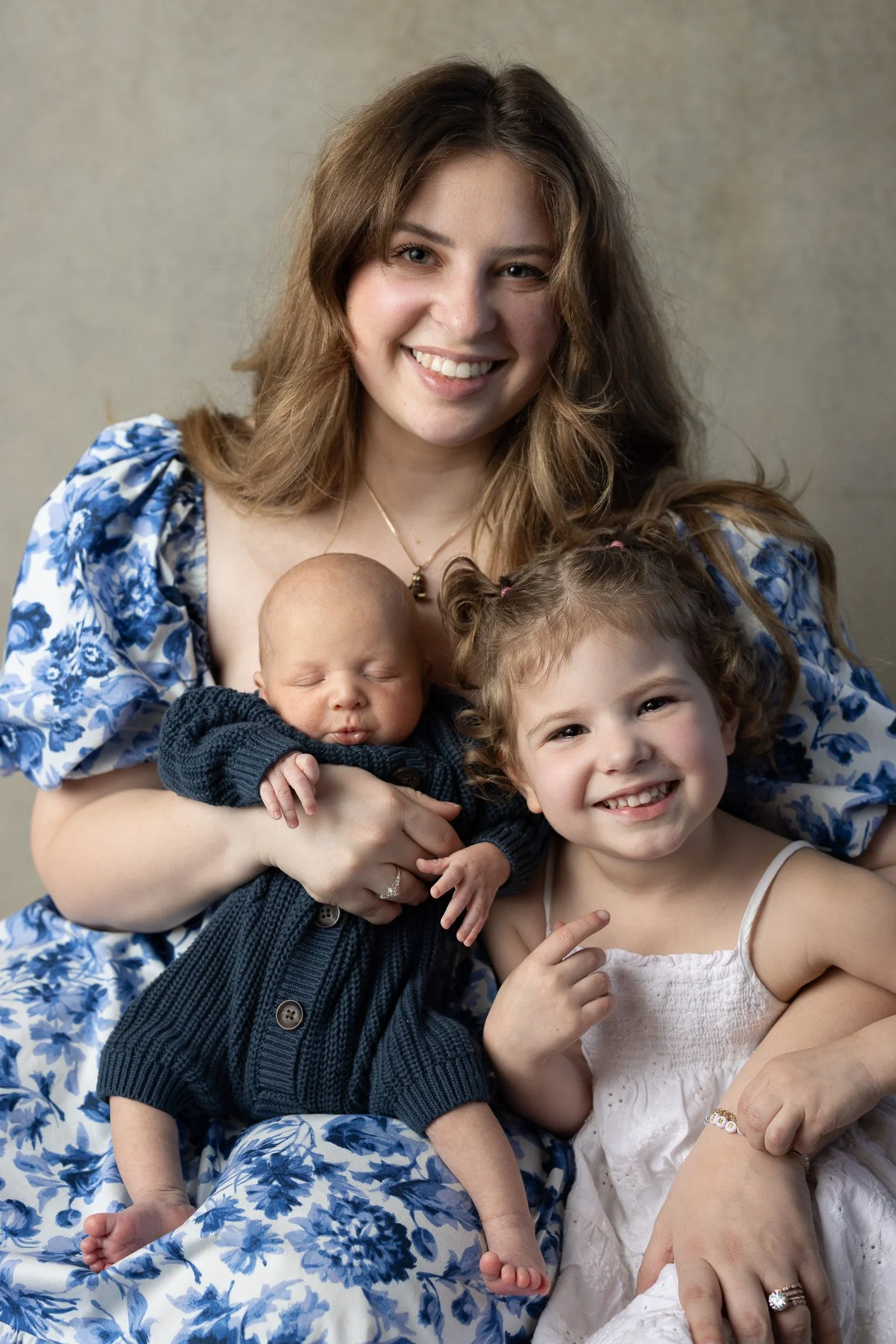 mom holding newborn baby and daughter
