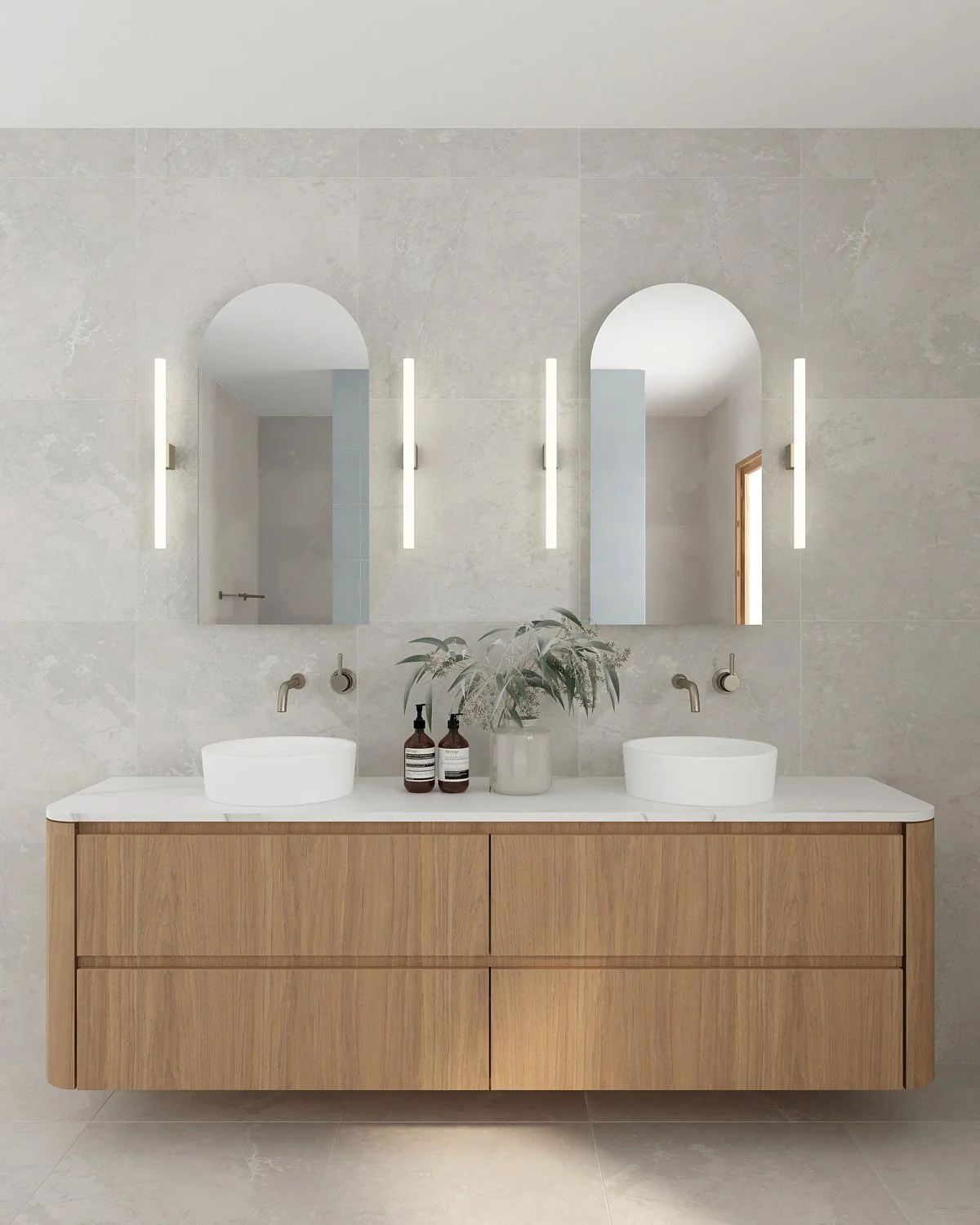 Modern bathroom vanity with dual sinks, large mirrors, and minimalist decor, including a plant and soap dispensers.