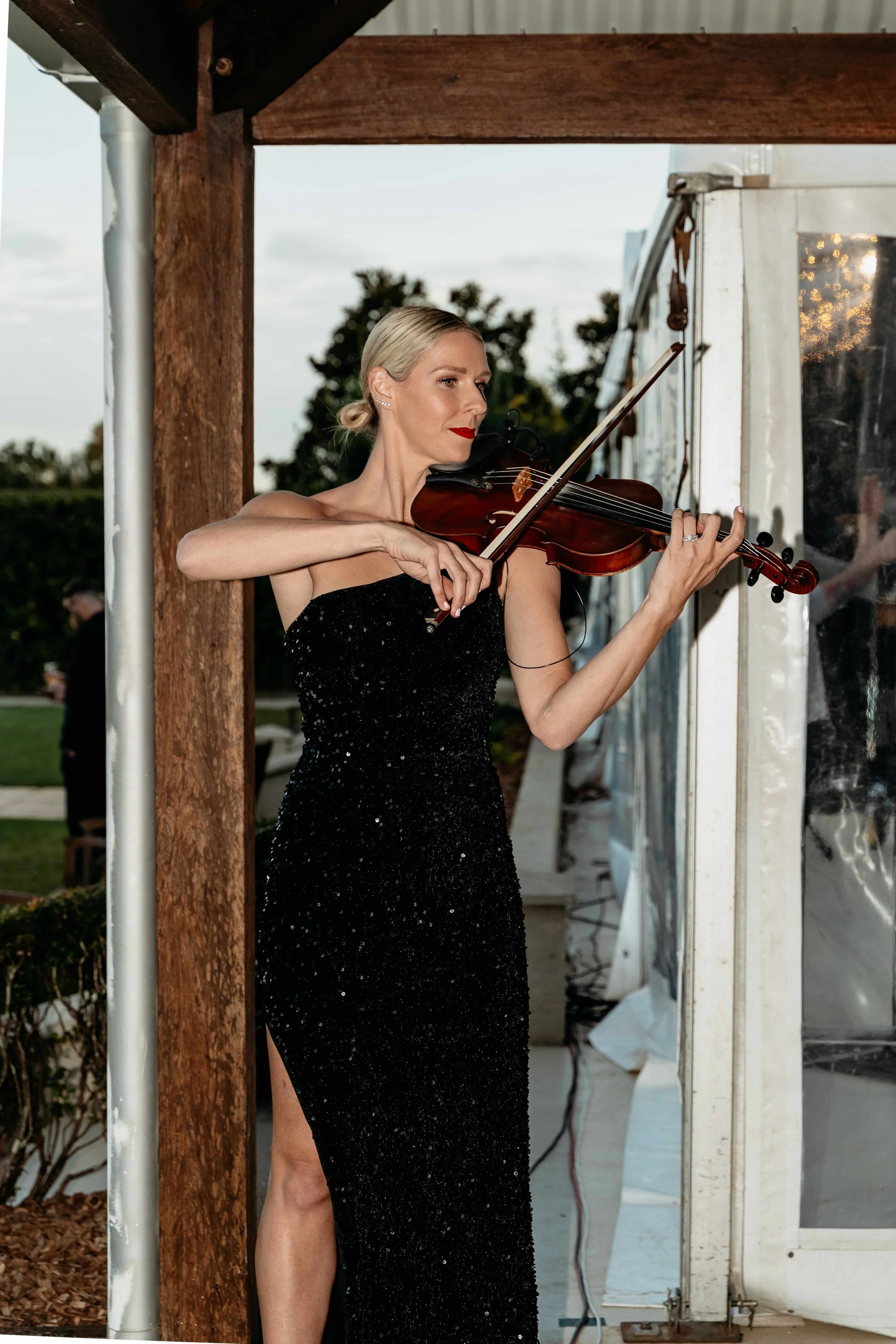 Violinist playing at elegant outdoor wedding reception at Flaxton Gardens