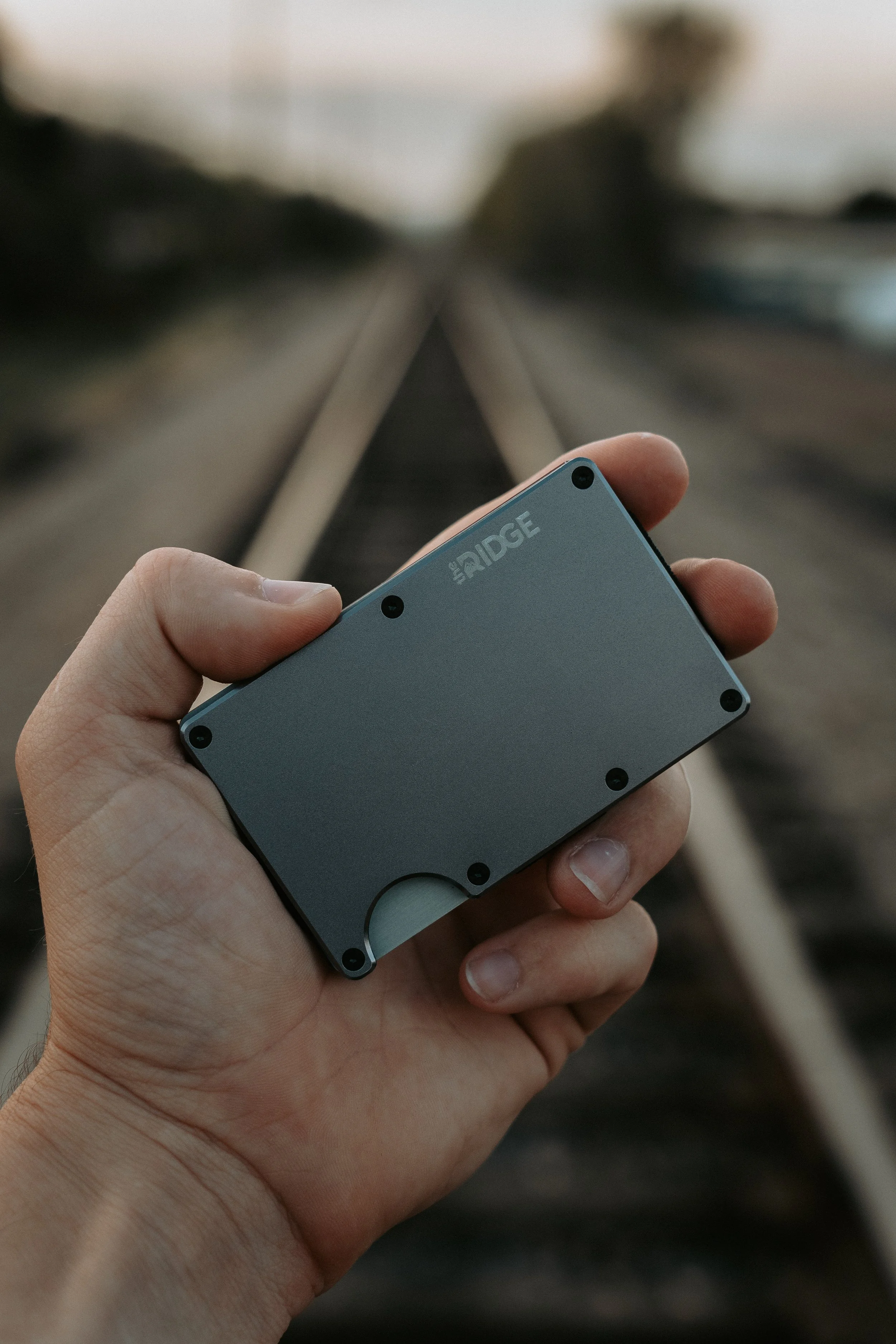 The Ridge Wallet being held on train tracks