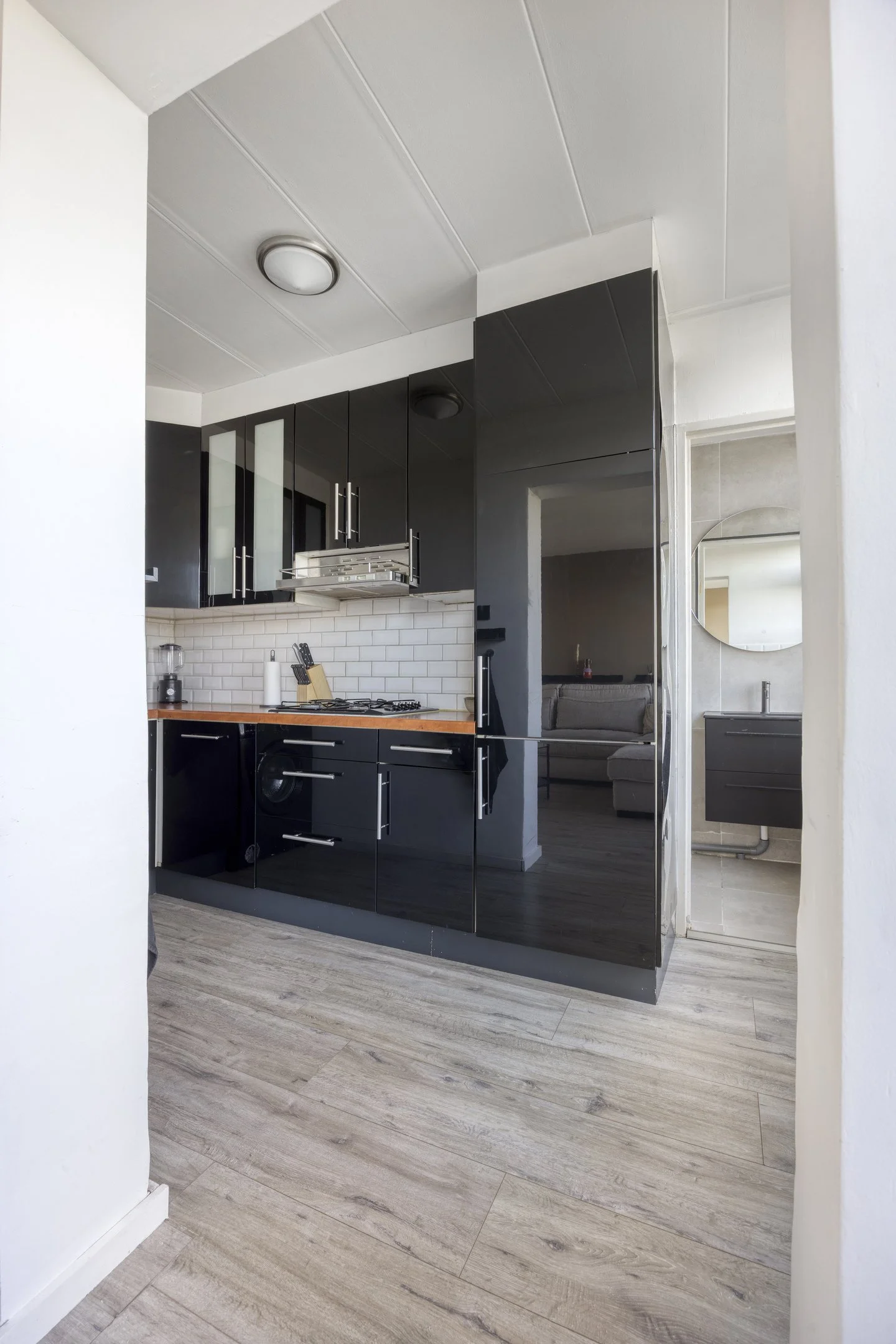 Functionele keuken met gasfornuis, koelkast en ruimte voor vaatwasser en oven, met brede doorgang naar de woonkamer, appartement Albert Cuypstraat 21 Capelle aan den IJssel.