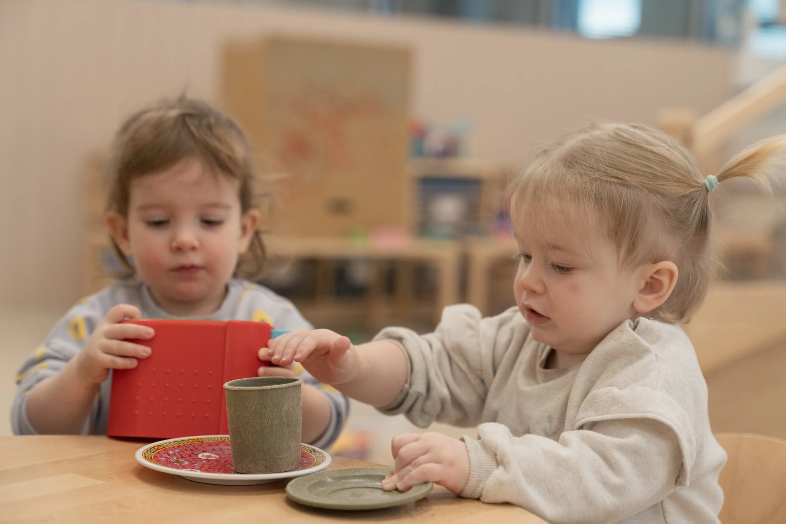 Child happily playing with a small toy on a play mat