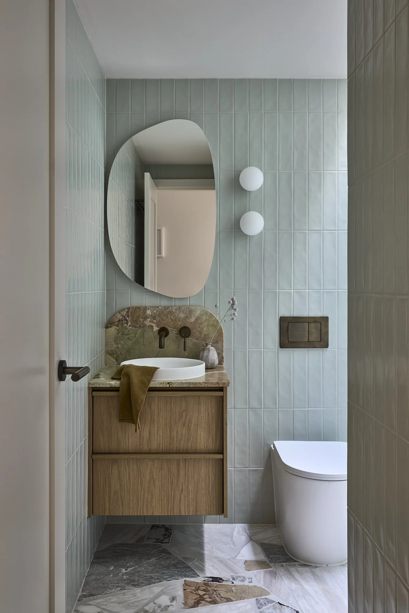 Arched mirror and natural stone vanity in a premium Sydney terrace renovation.