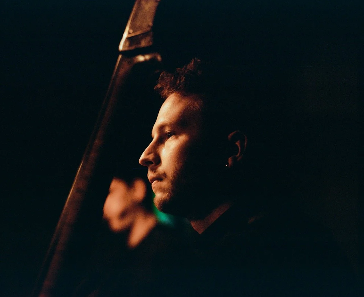 Porträt eines Mannes im Profil bei Dunkelheit, gedämpftes Licht beleuchtet sein Gesicht