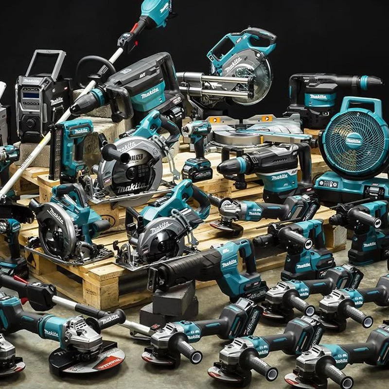 A variety of Makita power tools, including circular saws, drills, and handheld sanders, arranged on and around wooden pallets against a black background.