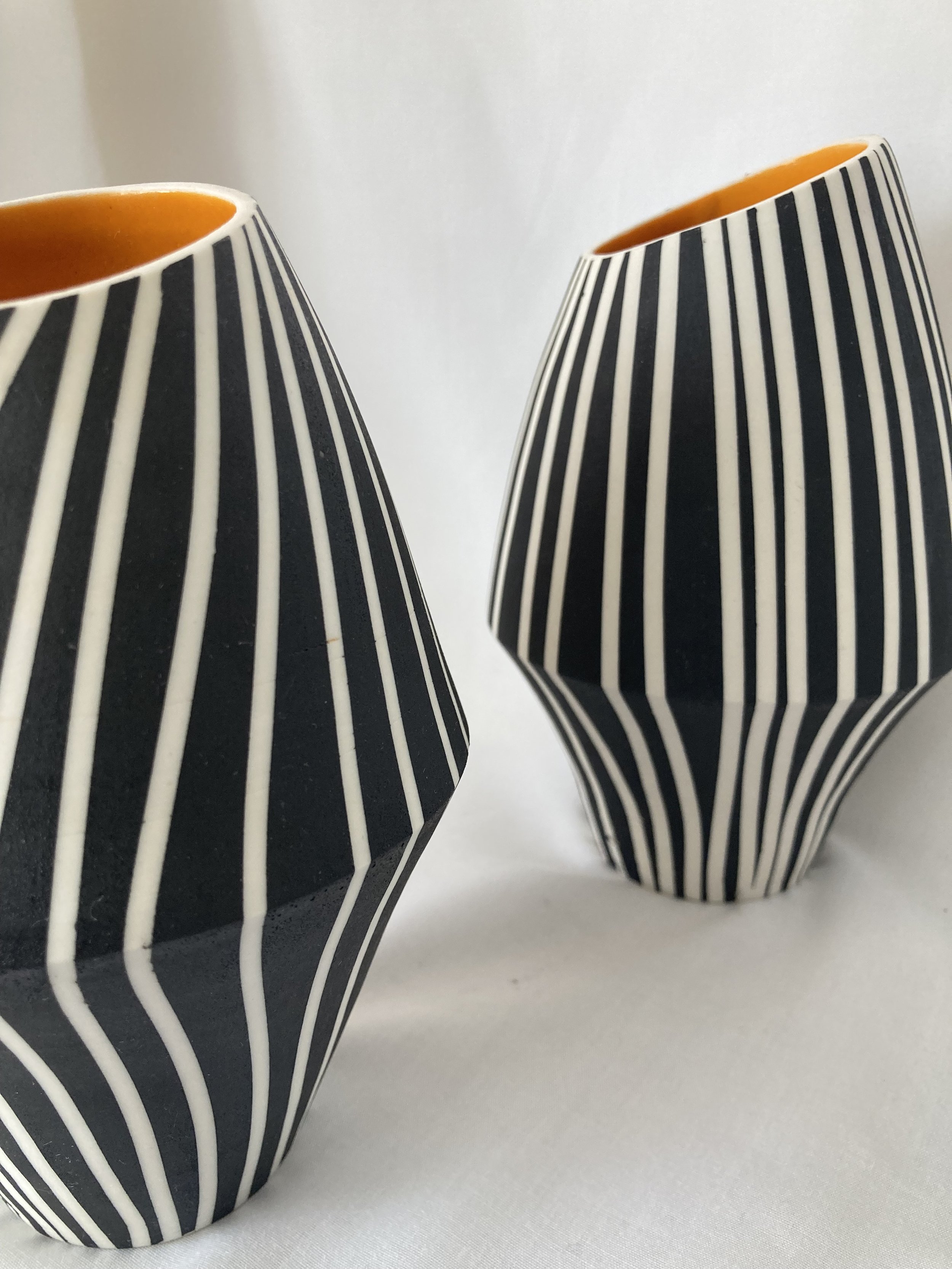 Jill tattersall 2 assymetric vases with angled opening to expose interior orange glaze.jpg