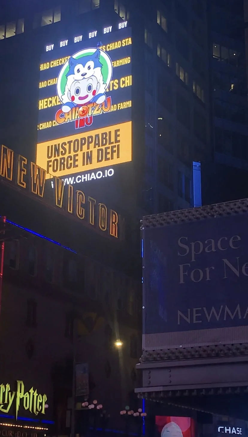 Bright digital billboard on a city building at night promoting ChiAIO, emphasizing 'Unstoppable Force in DeFi' with a cartoon character and the website URL www.chiao.io.