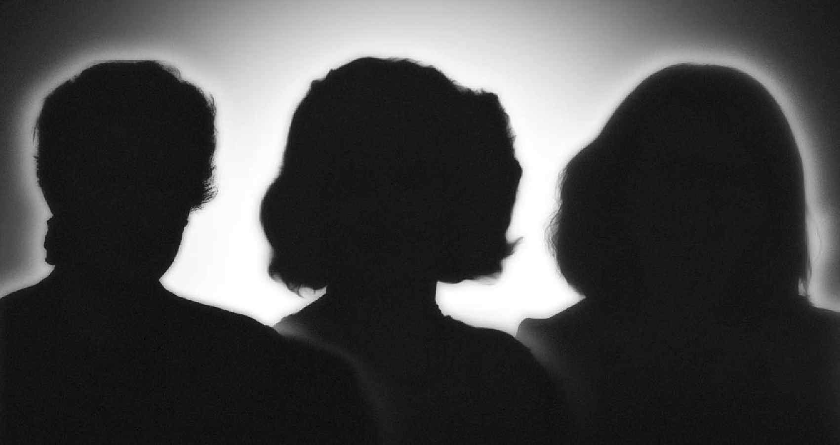 A black and white image with the silhouettes of three women.