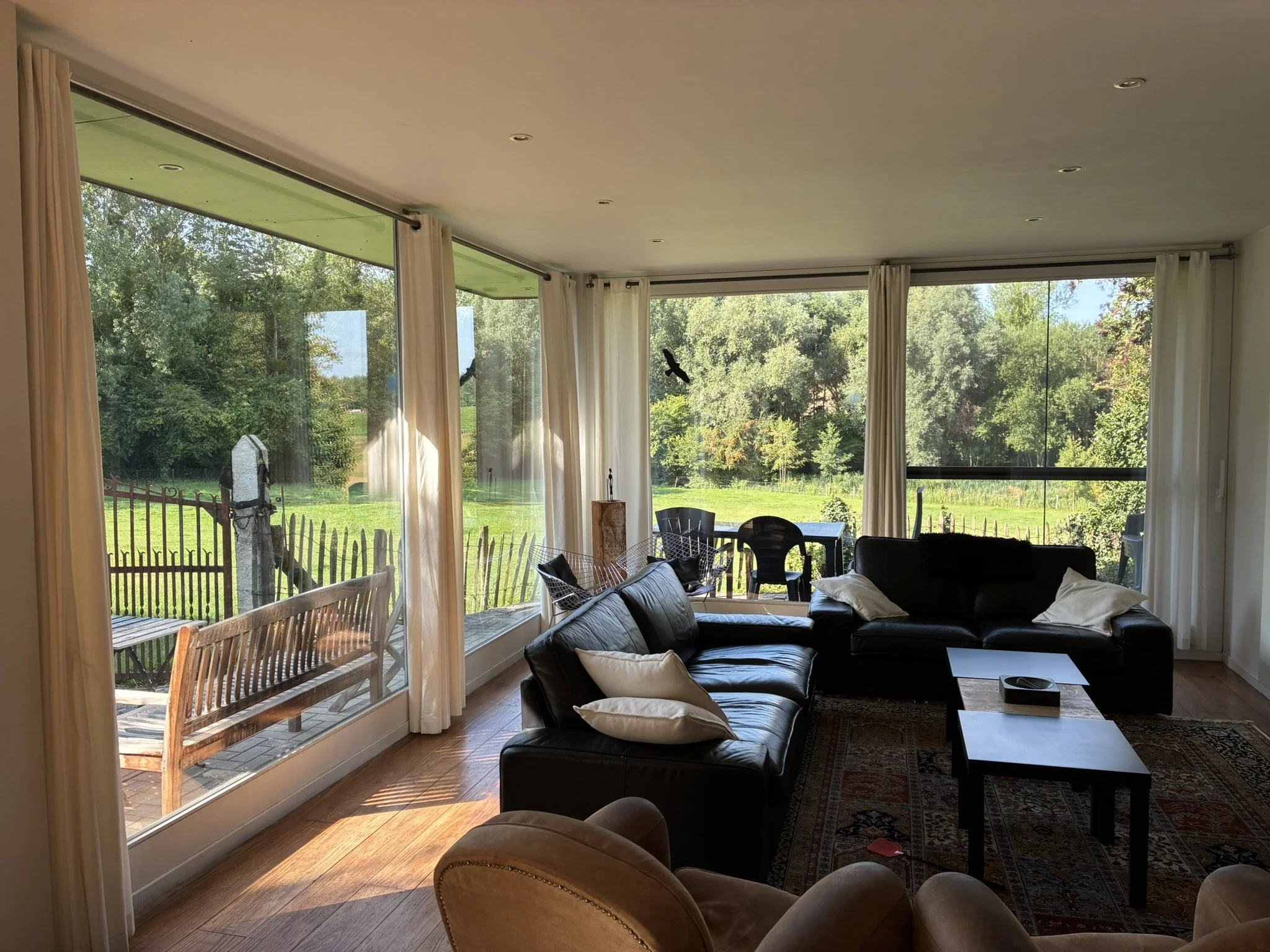 Zithoek met zicht op het terras en tuin van vakantiewoning De Waterkriek in Kuttekoven