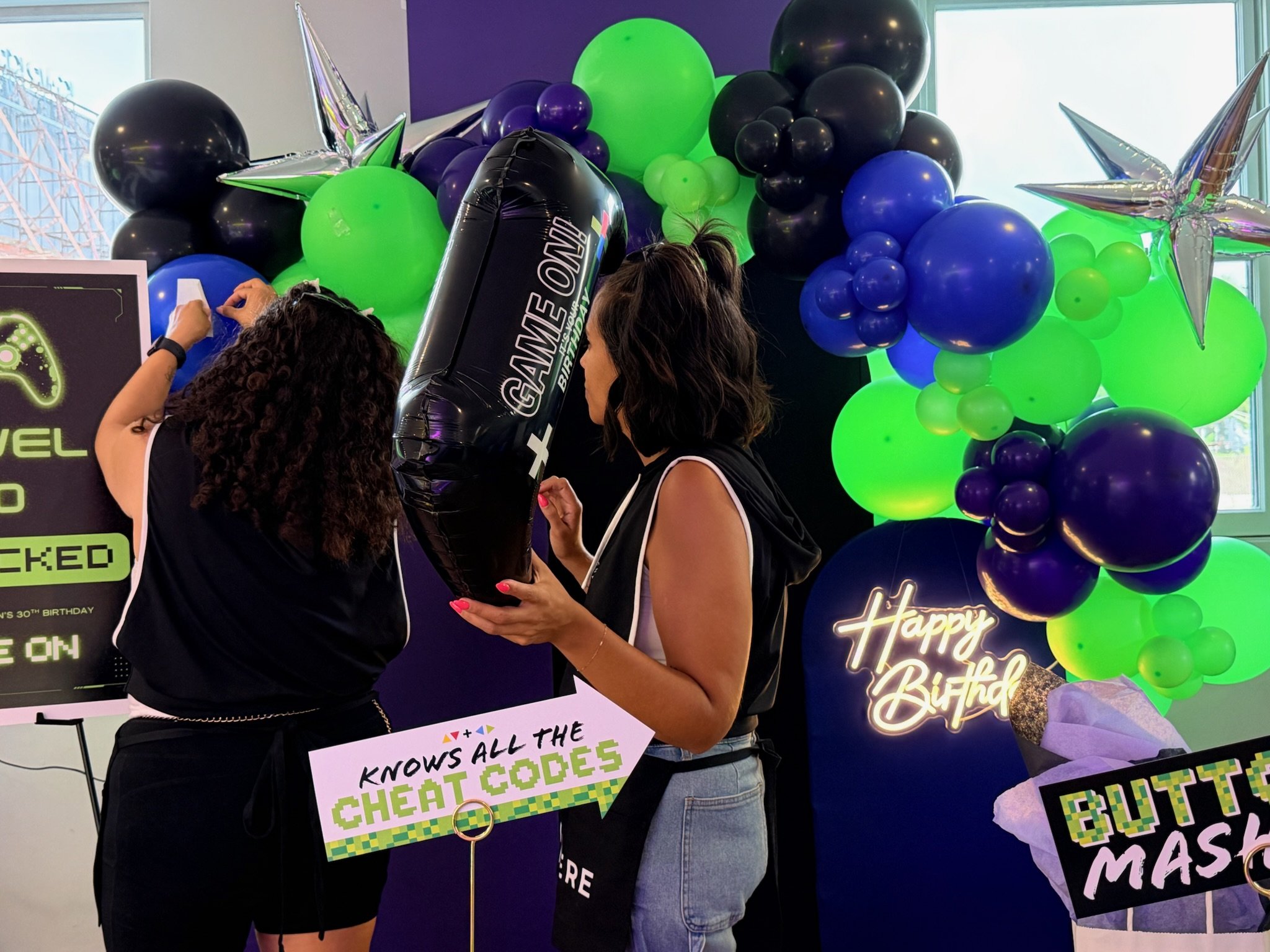 Barlyssa of Homemade Events installing a video-game inspired birthday backdrop at The Playhouse party room in Rochester, NY