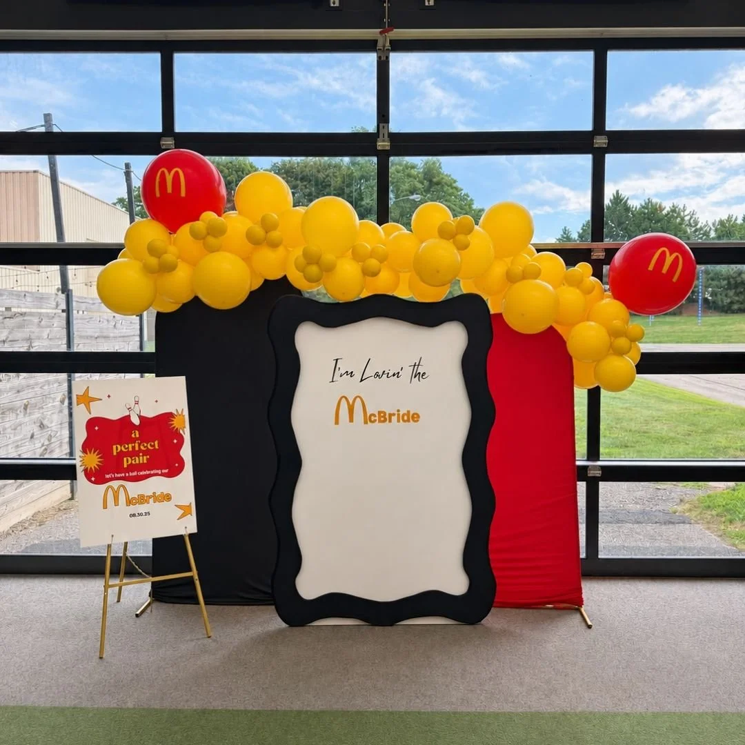 A McDonald's themed bridal shower backdrop setup in the party room at Radio Social in Rochester, NY