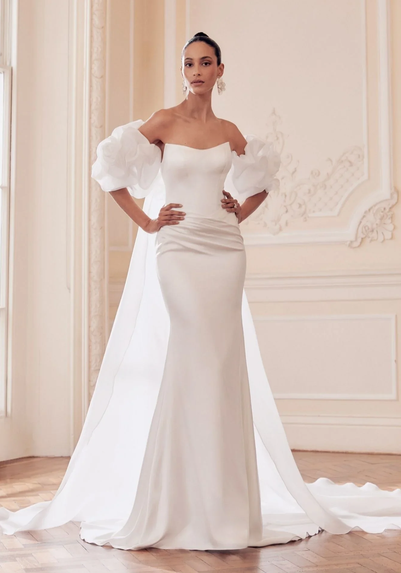 Kaunis merenneitomallinen hääpuku korsetti yläosalla ja lantiolta vedostettu helma. Puvun kanssa organza viitta offshoulder hihoilla.