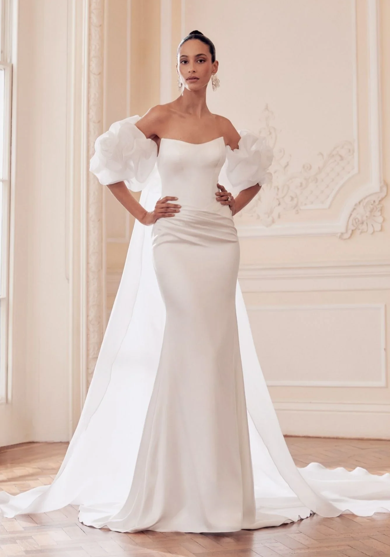 Kaunis merenneitomallinen hääpuku korsetti yläosalla ja lantiolta vedostettu helma. Puvun kanssa organza viitta offshoulder hihoilla.