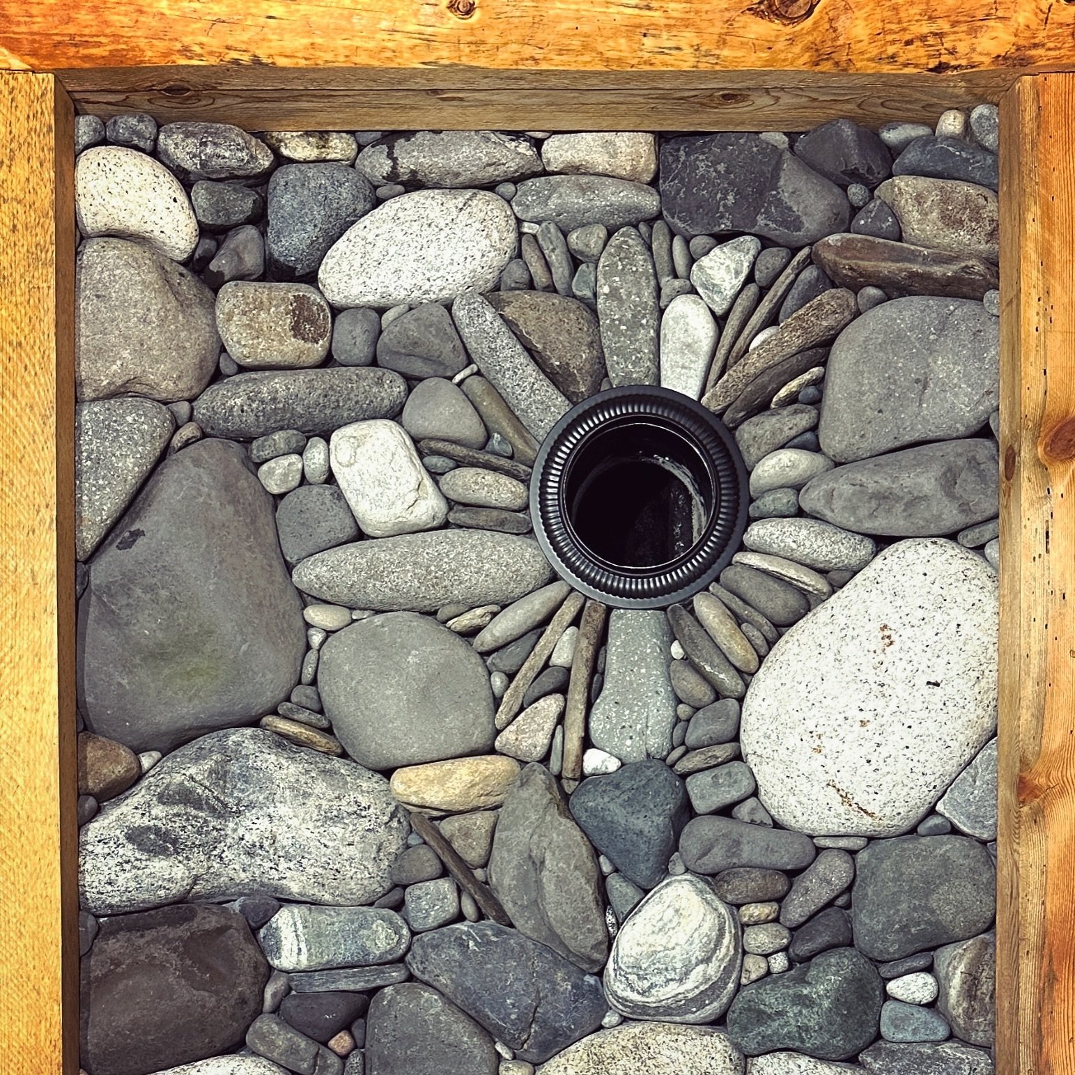 Stone framed with wood and a metal stove pipe framed with stone #millerstoneworks #stone #stoneart #stonework #stonemasonry #stonemason #naturalstone #drystackstone #design #stonedesign #construction #contractor #masonrycontractor #masonry #stonefire