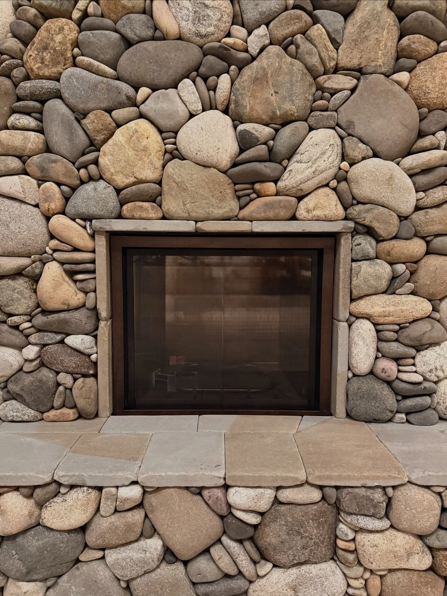 River rock fireplace with bluestone hearth #millerstoneworks #fireplace #masonry #stonework #riverrock