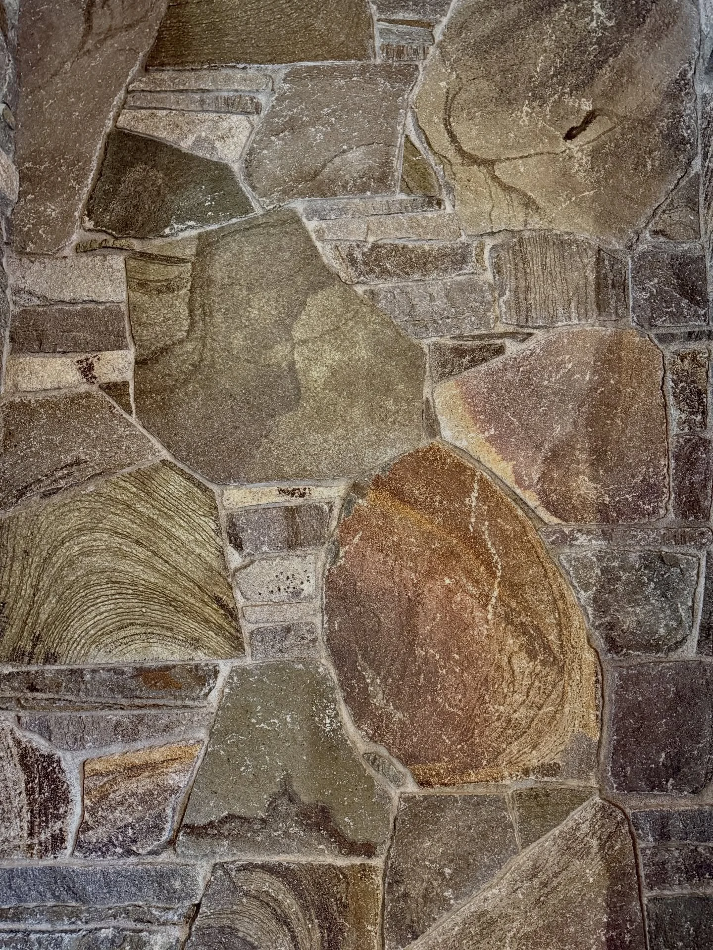 A close up on the mix of silver falls used in this stove backing #millerstoneworks #silverfallsstone #woodstove #masonry #stonemasonry