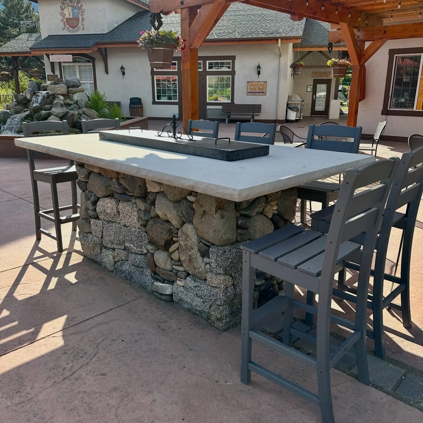 I built this fire table in the middle of winter, but it still looks good in the summer. That's a single piece of limestone for the tabletop, with a river rock and granite mix on the base #millerstoneworks #firetable #outdoorseating #masonry #stonewor