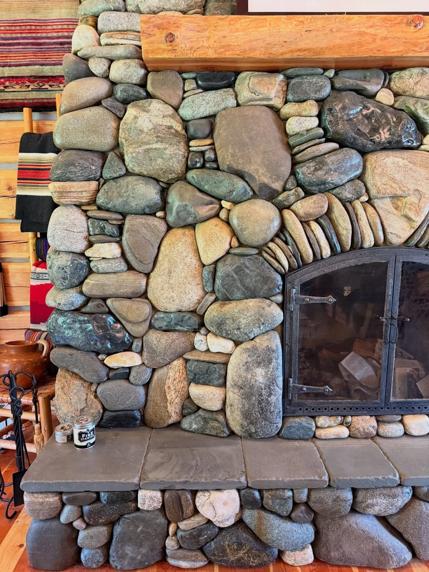Scale is always hard to judge from a photo - while most mantels sit within an arms reach of the ground, this one is actually 12 feet up because of the sheer height of the fireplace #millerstoneworks #fireplace #stonefireplace #stonemasonry #riverrock