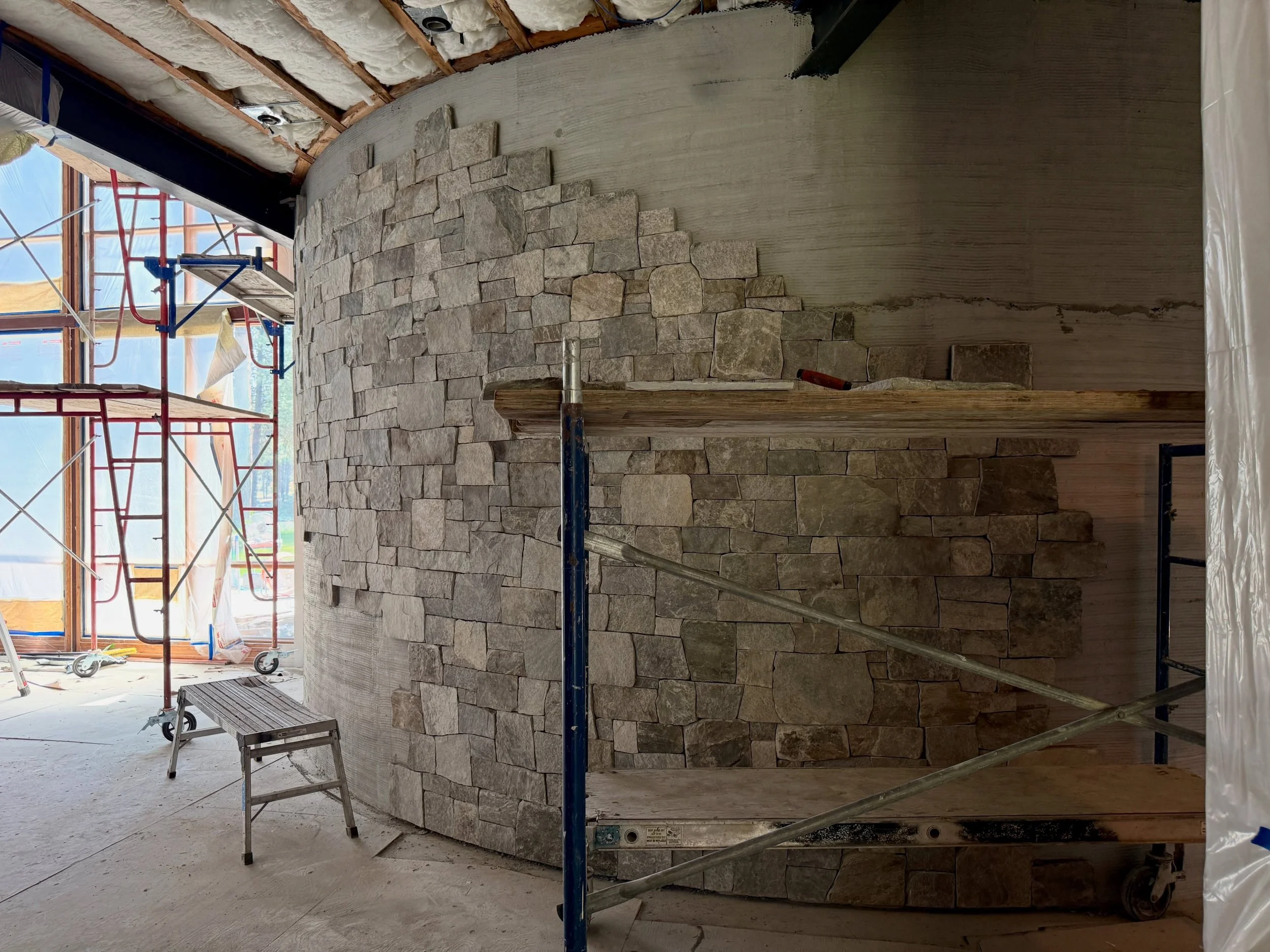 Making progress on the curved wall. Because stairs are going on the left side, we have to leave certain sections open until more carpentry is complete. That dance between subs is all part of construction #millerstoneworks #stonemasonry #masonry #ston