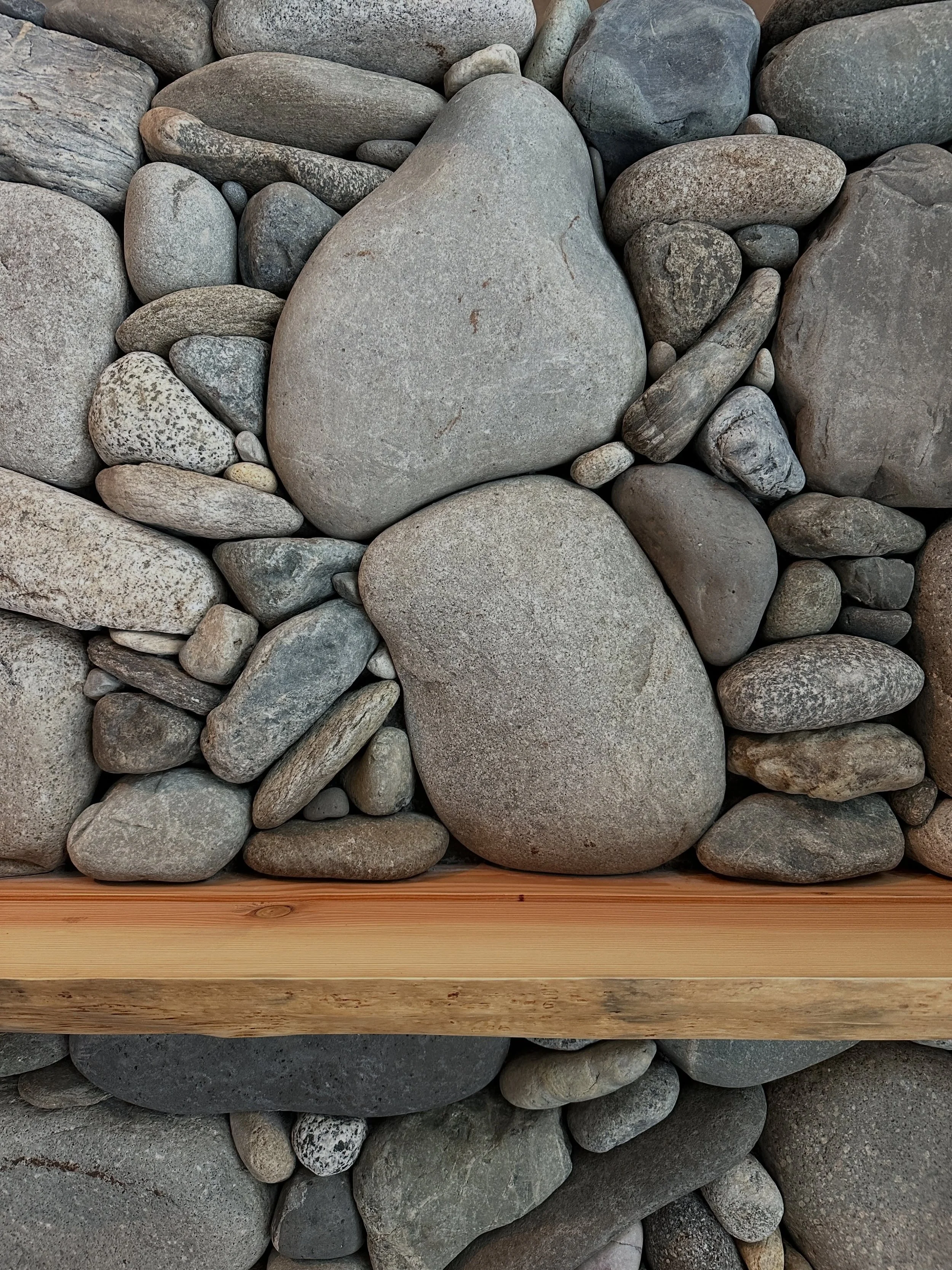 It might seen random, but there is thought behind the design, like this spot above the mantle that has two symmetrical winding stacks on the sides of the larger stone #millerstoneworks #riverrock #design #stonedesign #stonemasonry