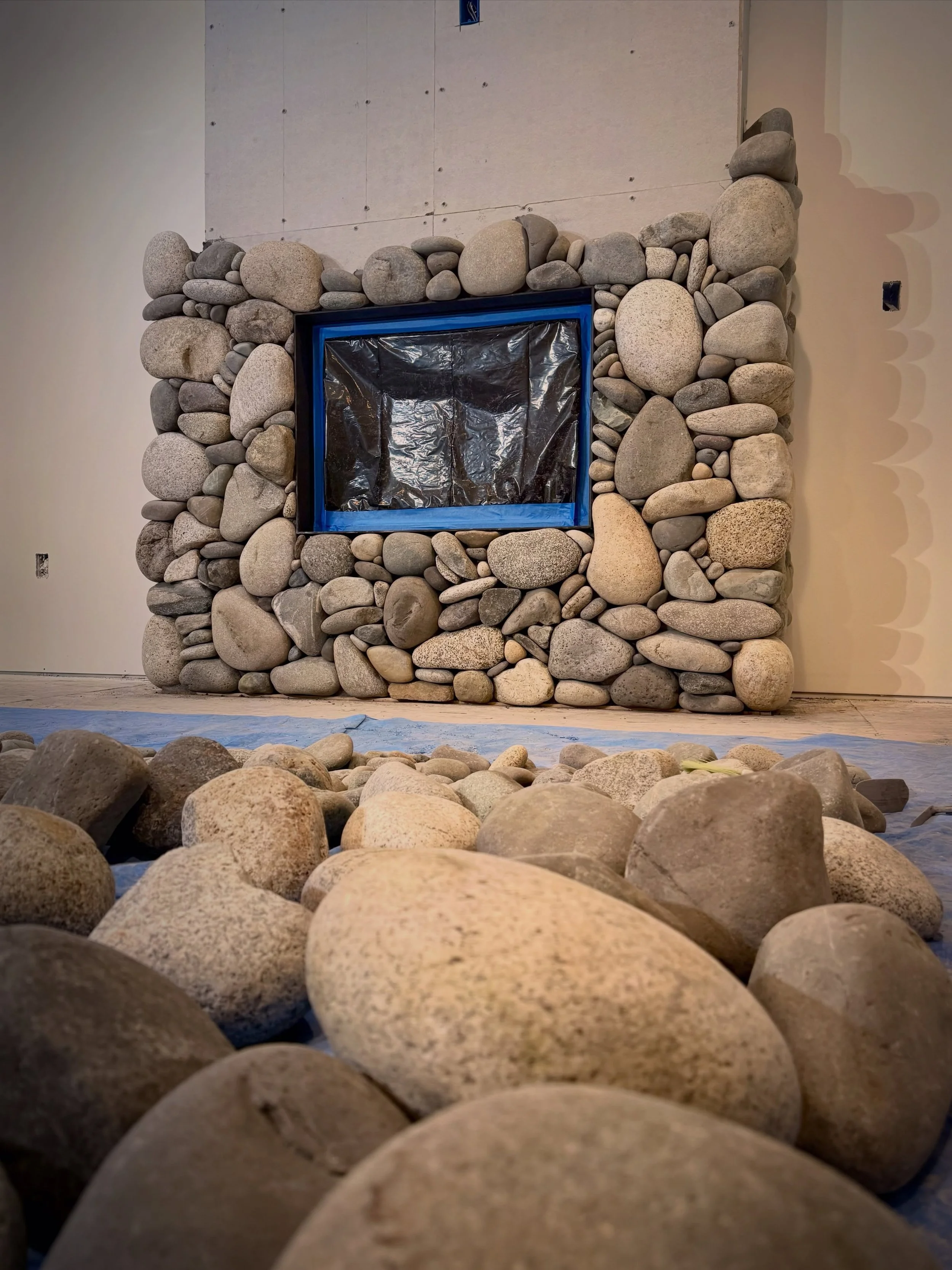 View from the floor of this in-progress river rock fireplace #millerstoneworks #riverrock #fireplace #stonemasonry #stonedesign