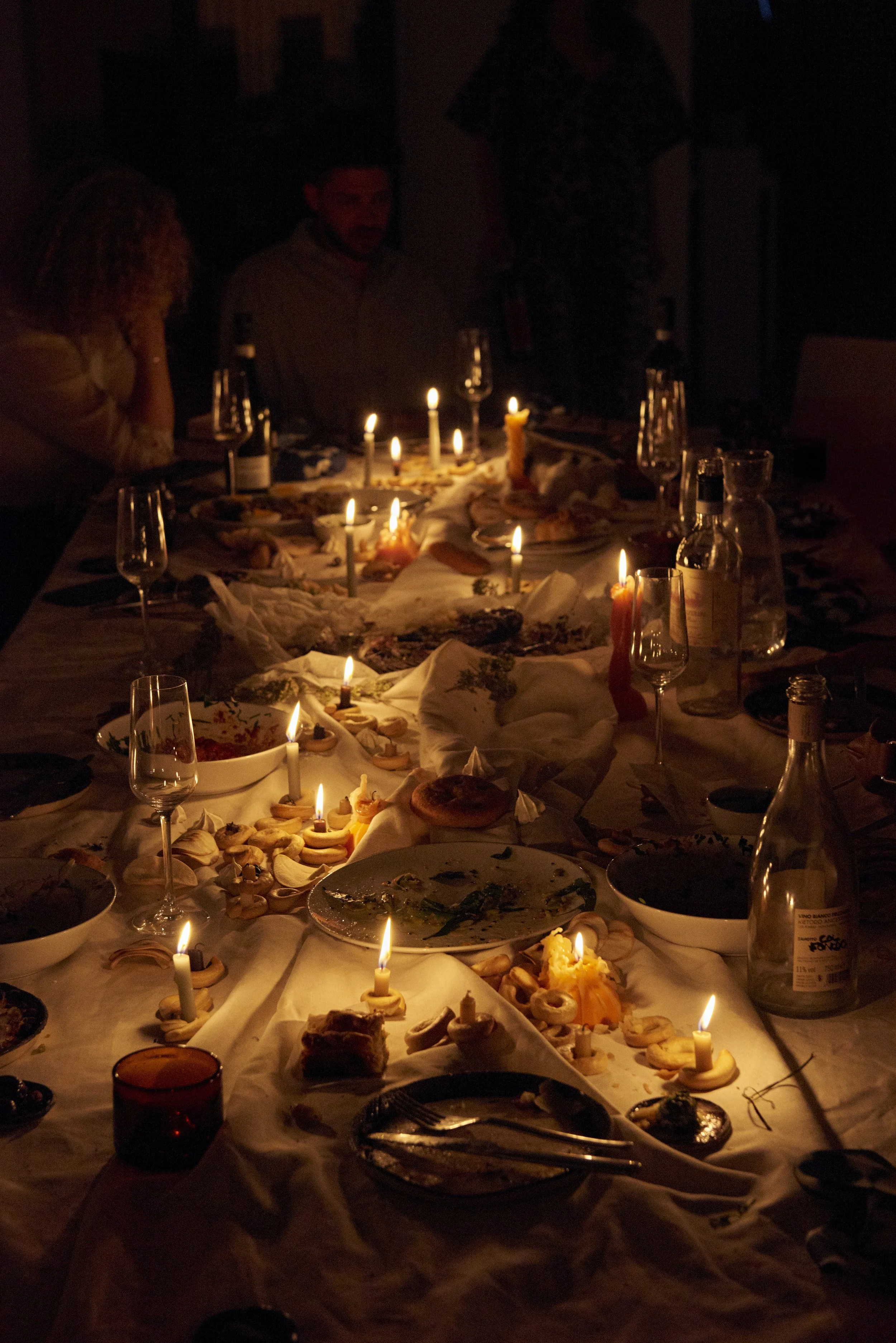 candlelit table with plates and food