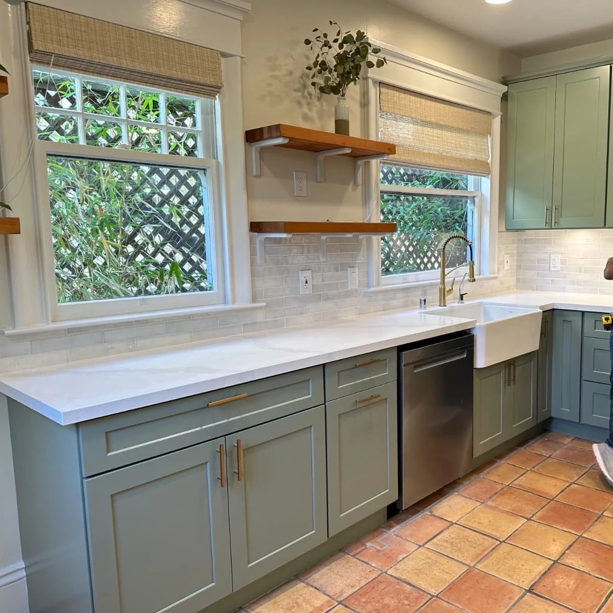 Complete kitchen remodel with custom shaker cabinets, quartz countertops, farmhouse sink, updated lighting, new appliances, and tile backsplash installation.