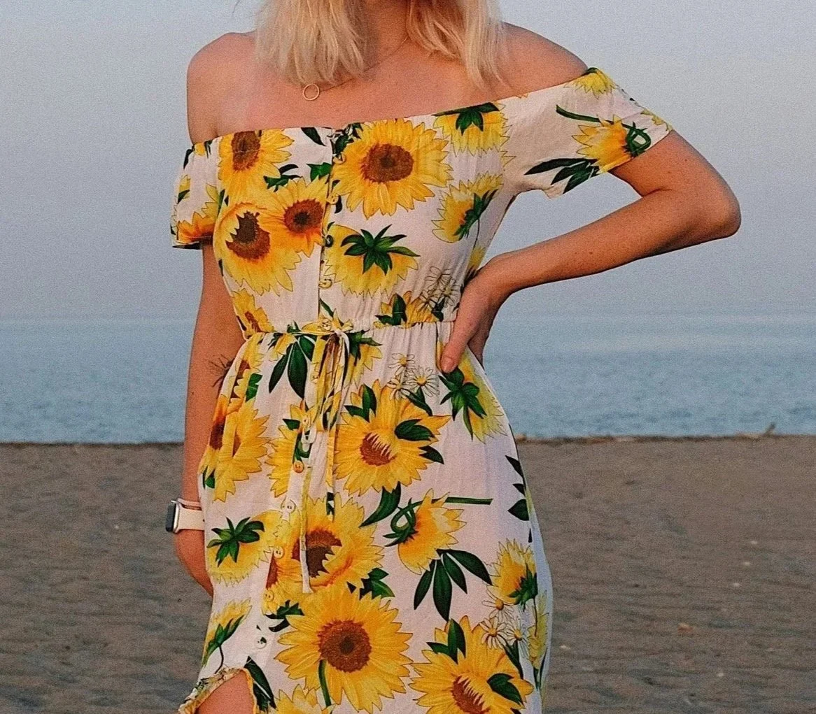 Woman wearing a dress covered in large yellow sunflowers