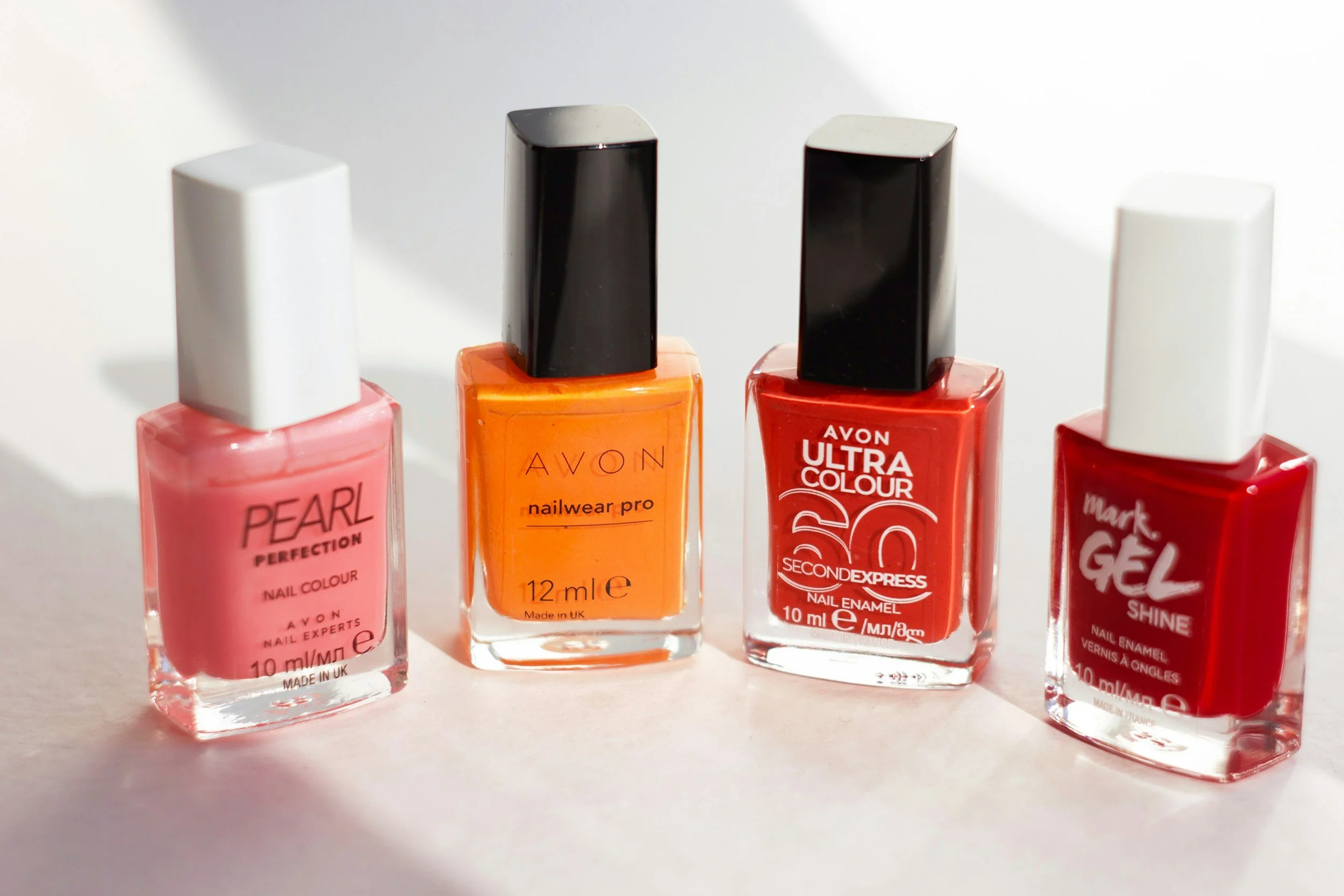 Small square bottles of nail polish in iconic Gamien colors like hot pink, orange, and red