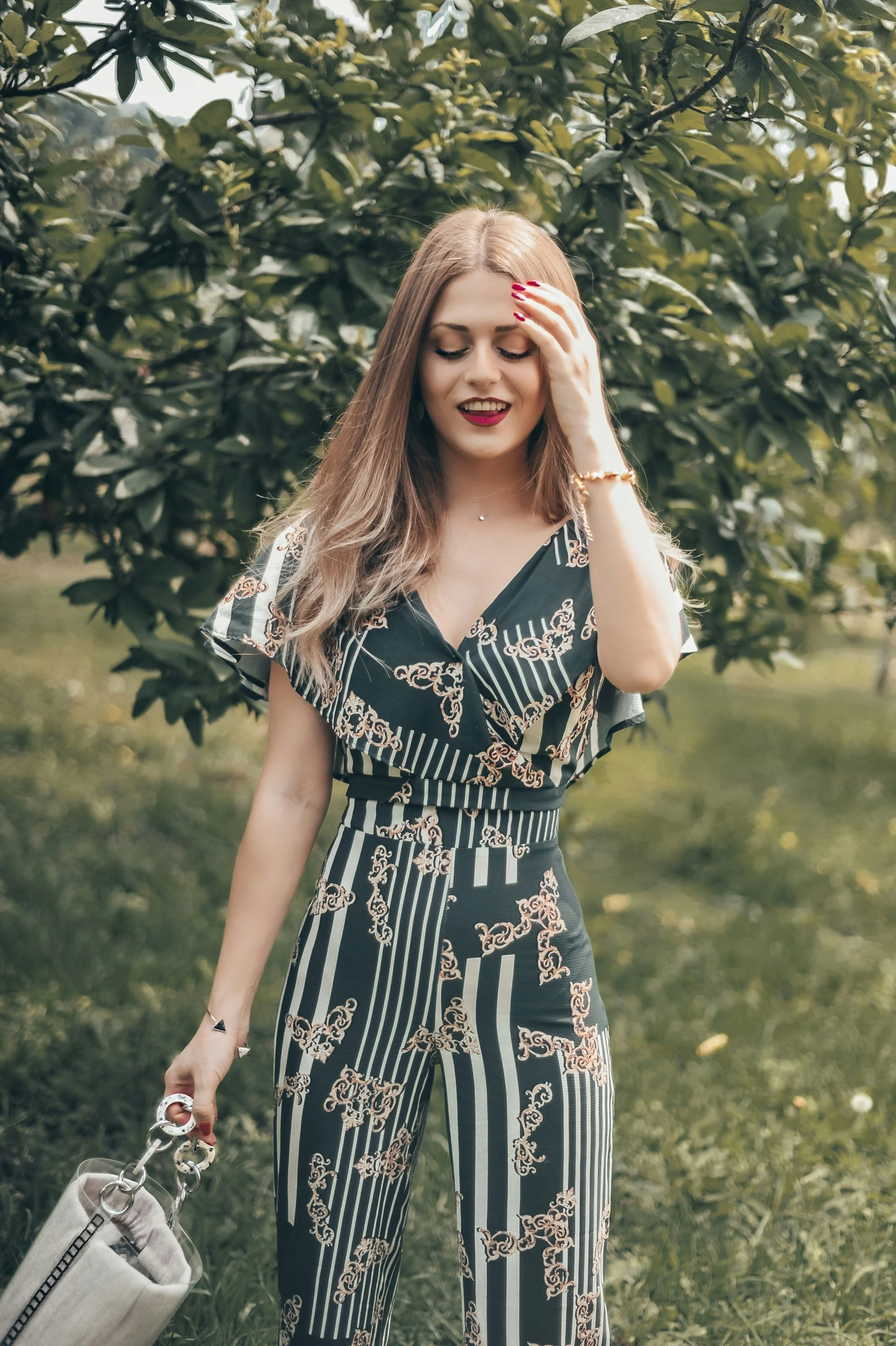 Woman wearing a glamorous jumpsuit with curving and linear detail