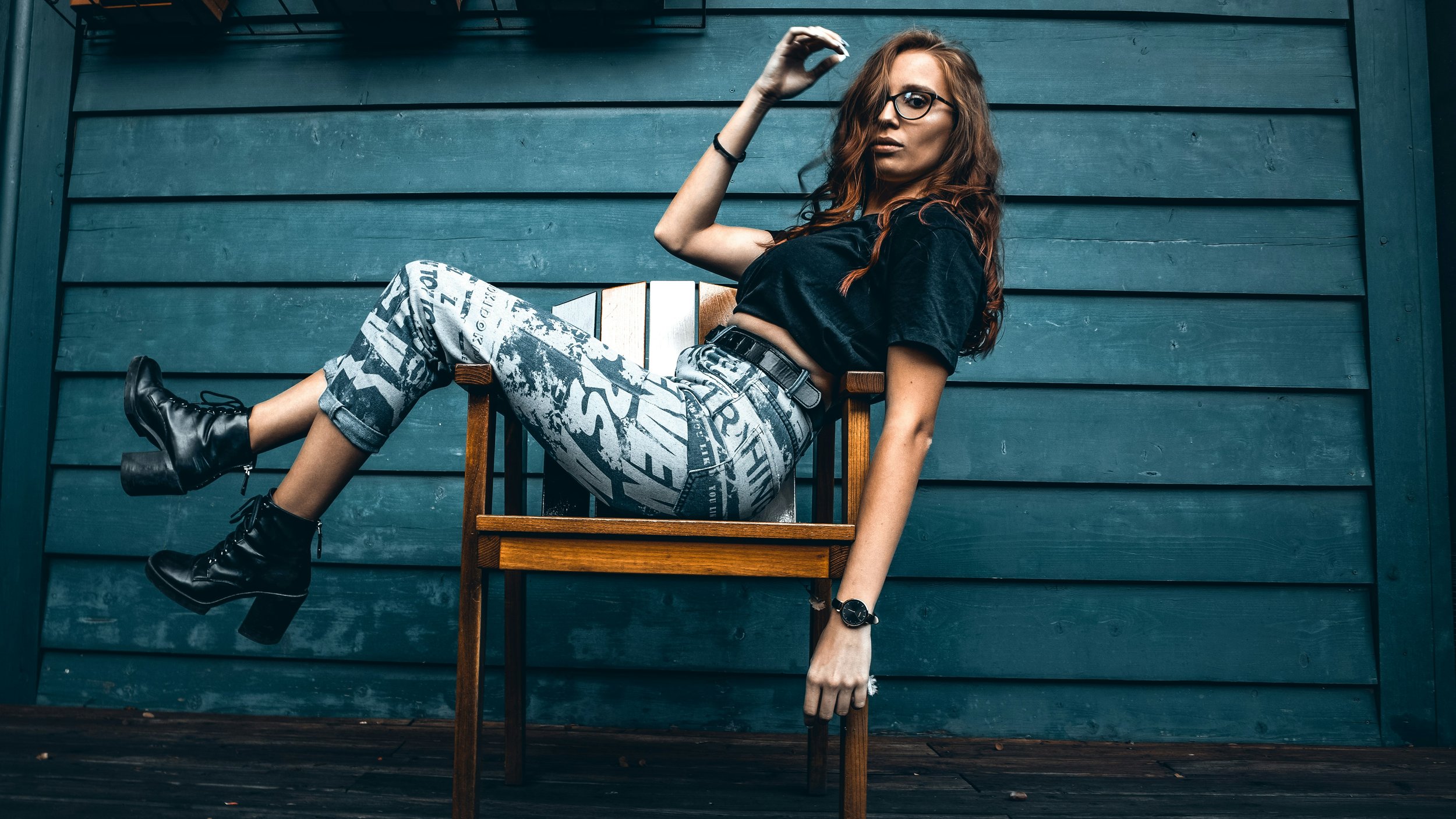 Woman wearing pants with large graphic lettering and leather ankle boots, showing the edgier side of Gamine beauty