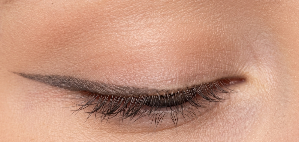 Thin, curving Ethereal winged eyeliner shown with eye closed
