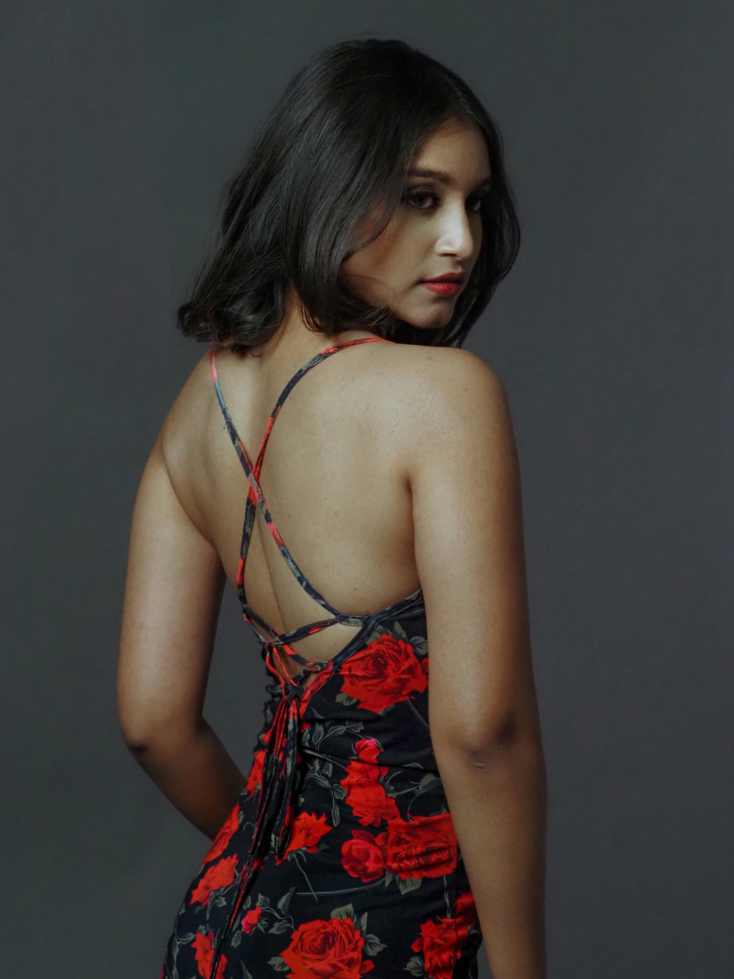 Woman wearing a black dress with lush red rose print