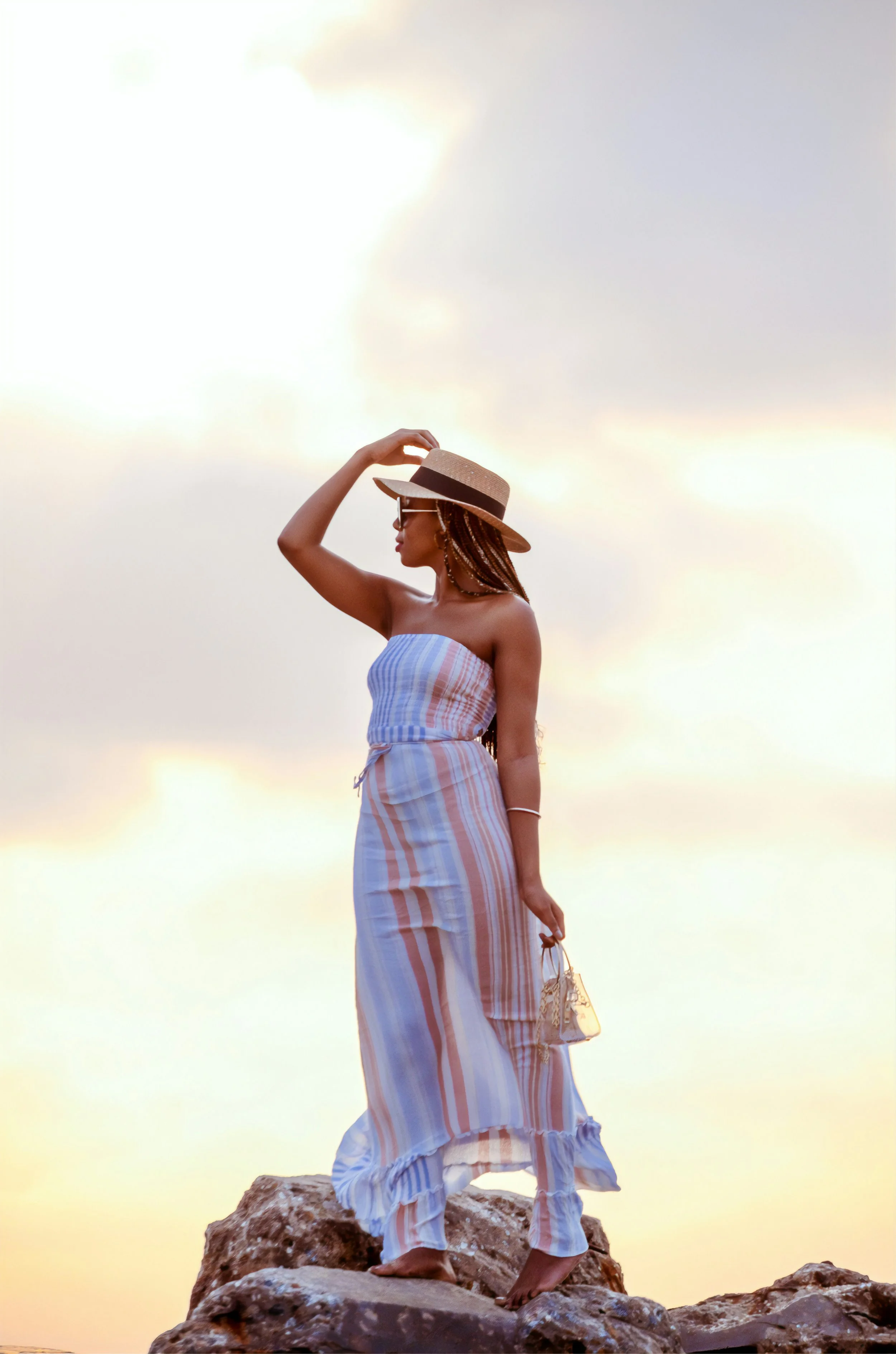 Woman wearing pinstripe dress standing on a rock