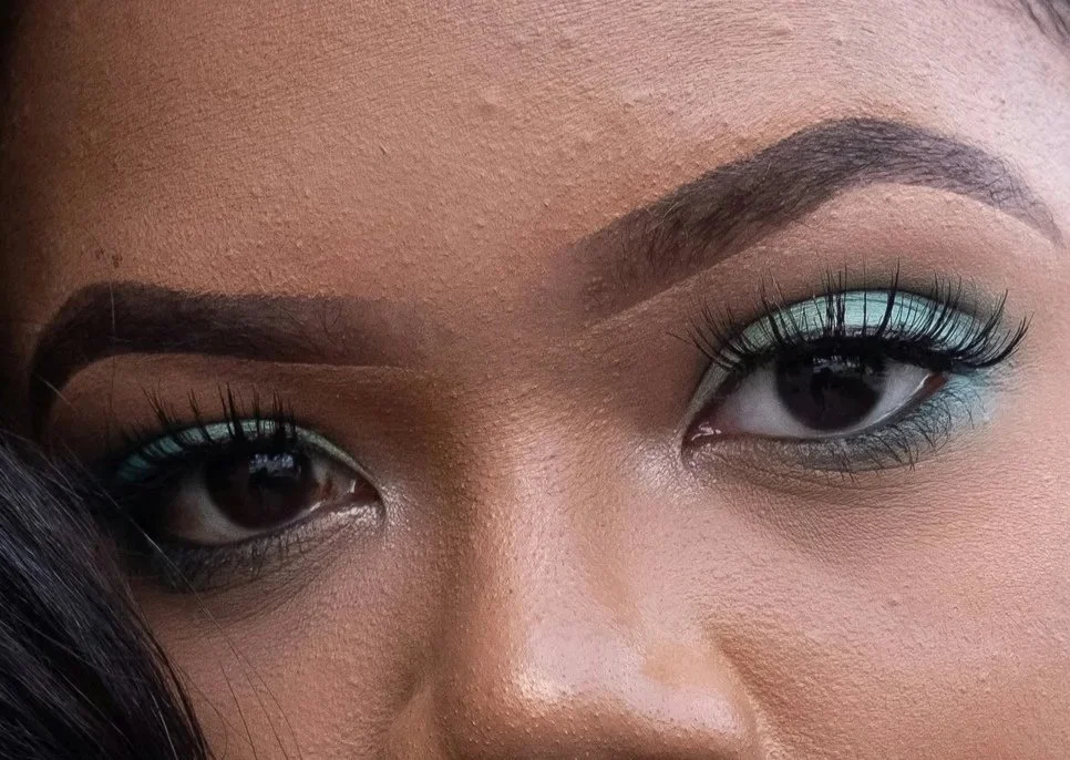 Model wearing teal eyeshadow all over the her eyelids and beneath lower lashliine