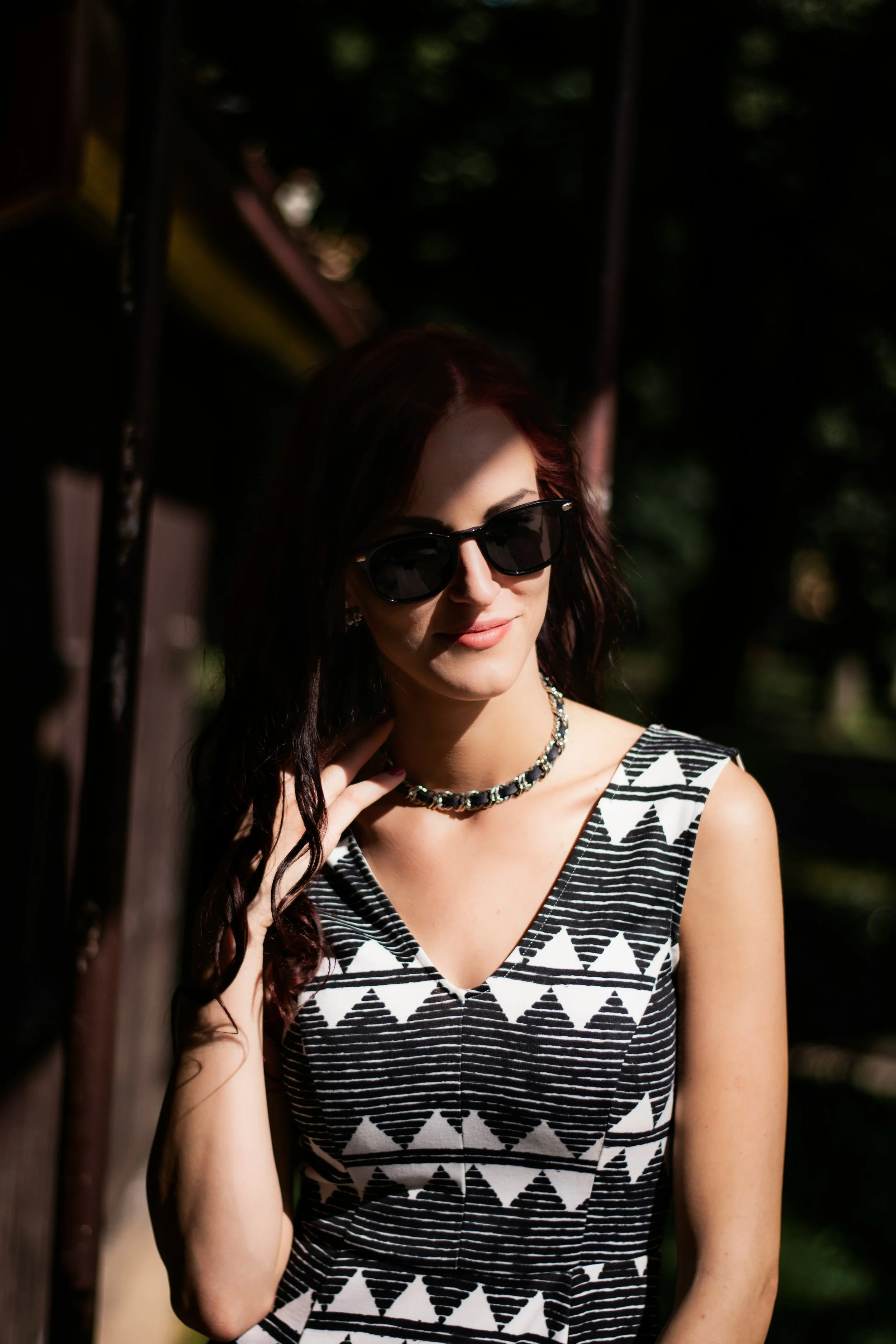 Woman wearing a choker necklace and a top featuring black and white stripes and triangles