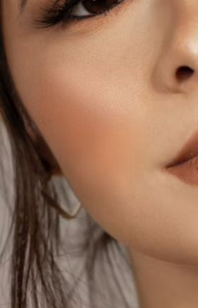 Woman of color wearing blush and highlighter that emphasize the short, angular Gamine lines in her face