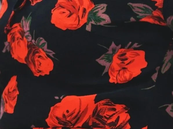 A lush red and black rose print symbolizes the glamour of the Romantic face essence