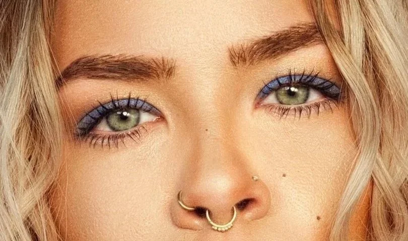 Model with green eyes wearing blue eyeshadow all over her eyelids