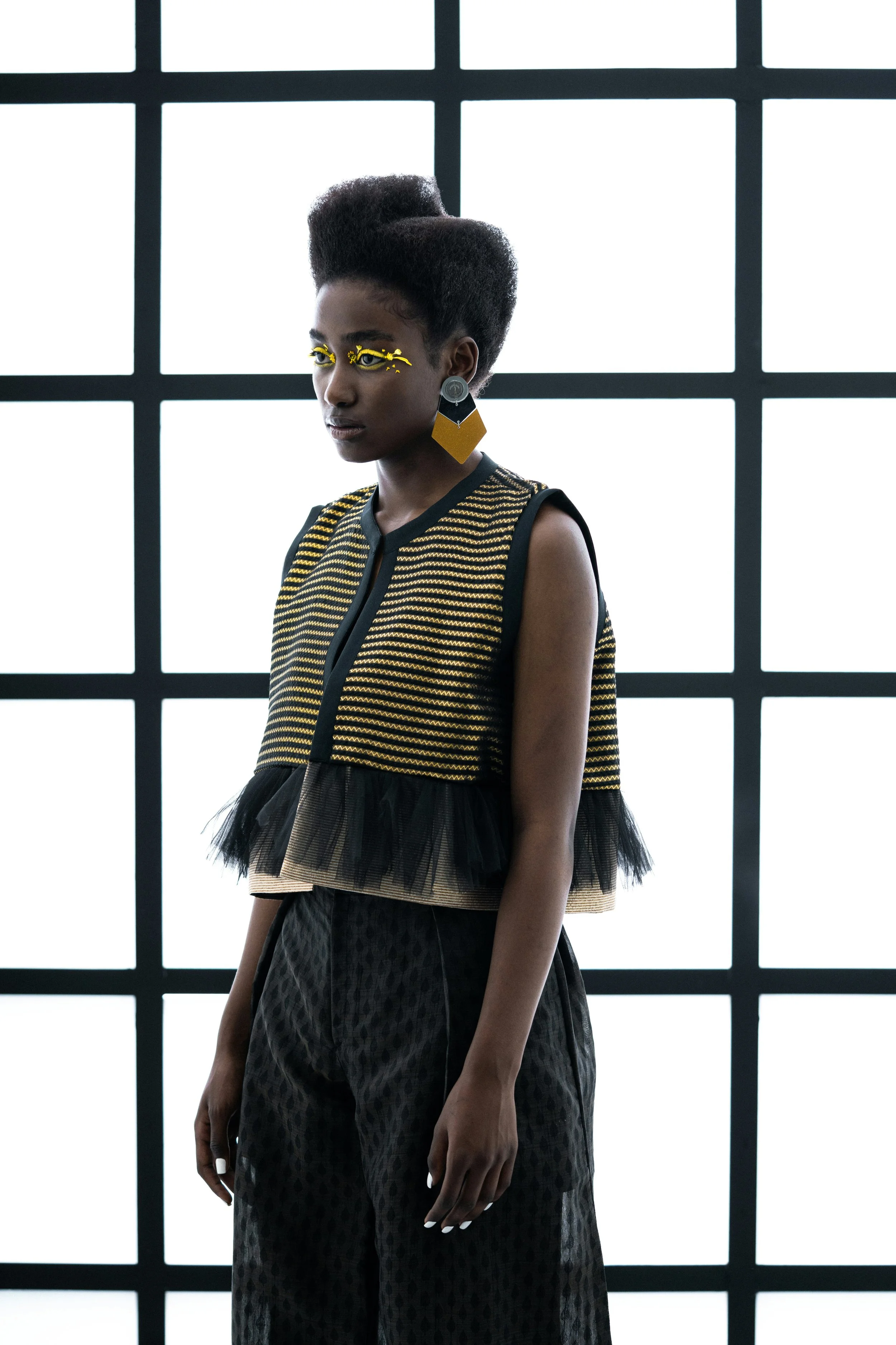 Woman wearing a top with yellow chevron paired with pants with a small diamond pattern