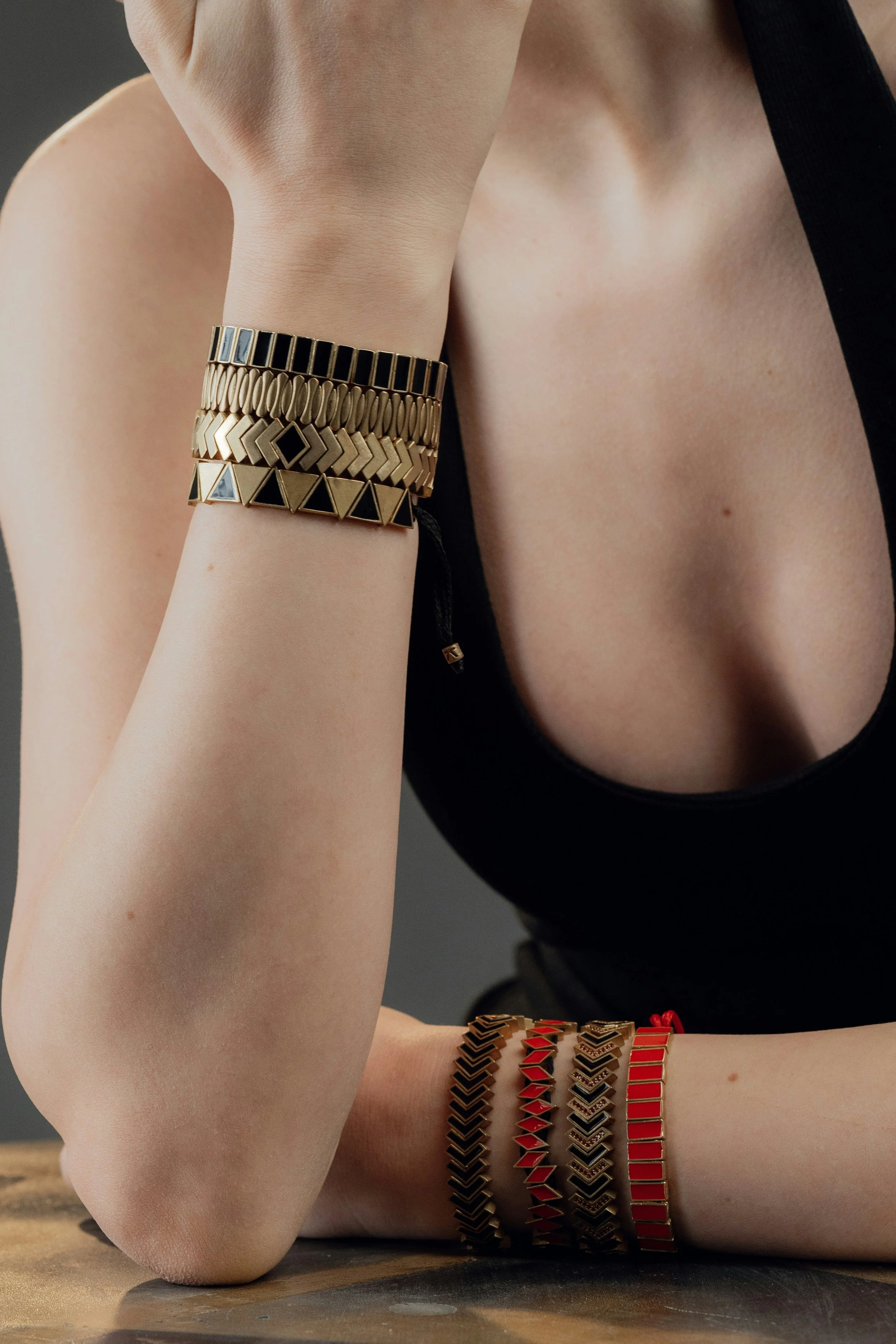 Woman wearing braceletts with different small repeating angular patterns--triangles, rectangles, diamonds